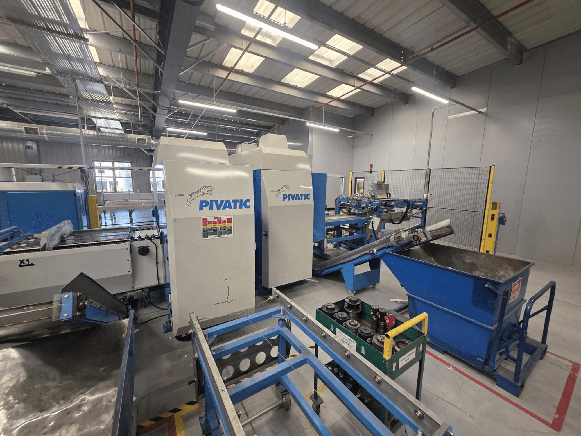 CNC-Stanzmaschine Pivatic PCC80-e TT HT, Vorderansicht mit Betriebsaufstellung, Förderband und Abfallbehälter.