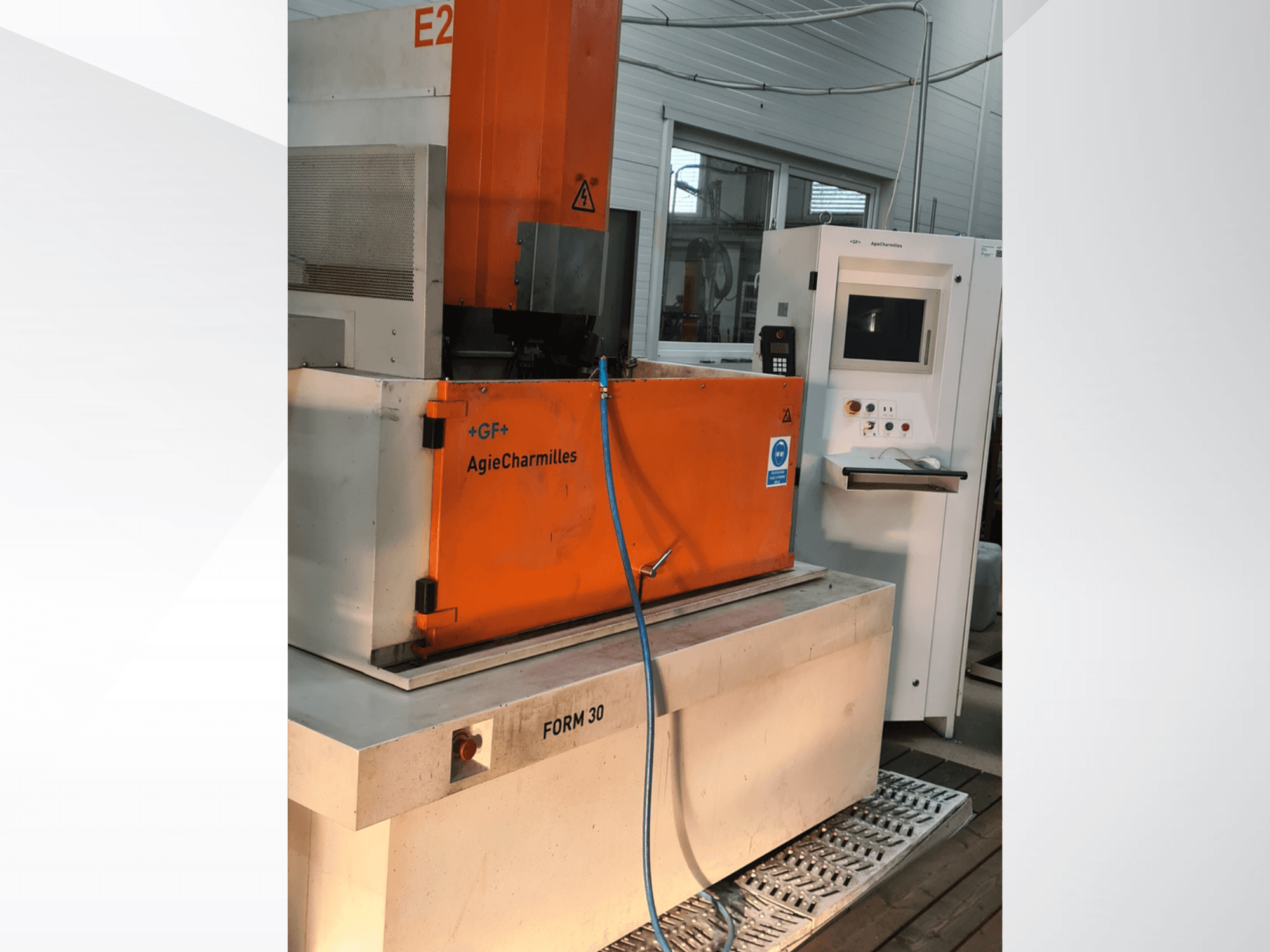 AgieCharmilles FORM 30 Senkerodiermaschine, Vorderansicht, mit orangefarbenem Schaltschrank und sichtbarem Wasserschlauch.