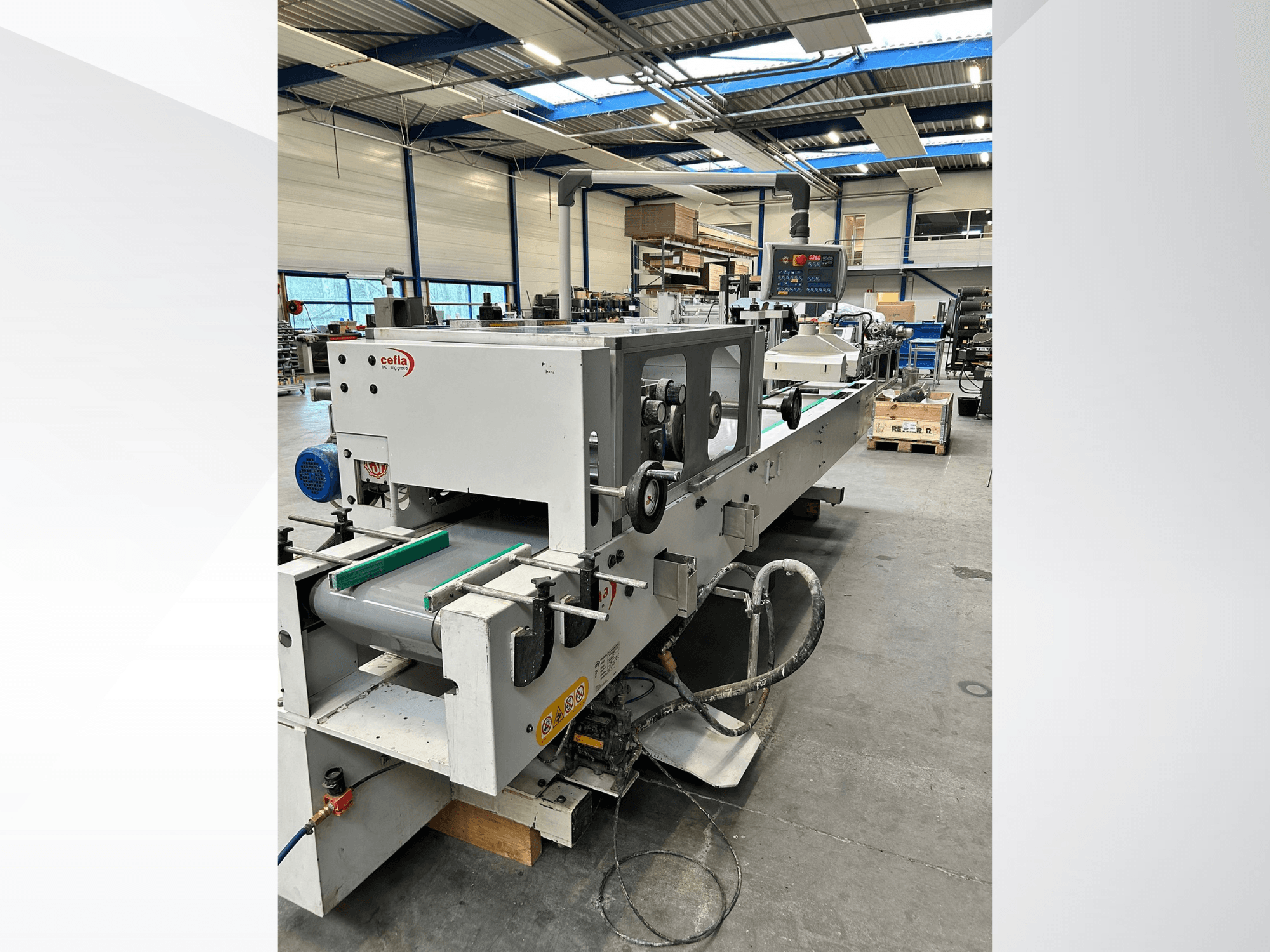 Vorderansicht der CEFLA Smartparquet MRF-2VS/300 Holzbearbeitungsmaschine mit Bedienfeld und Förderband mit grünen Rollen.