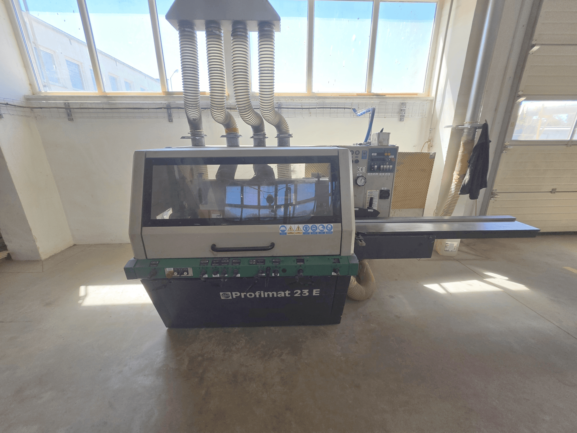 WEINIG DIMTER PROFIMAT 23 E Holzhobelmaschine, Vorderansicht, mit Bedienfeld, Vorschubtisch und Absaugschläuchen.