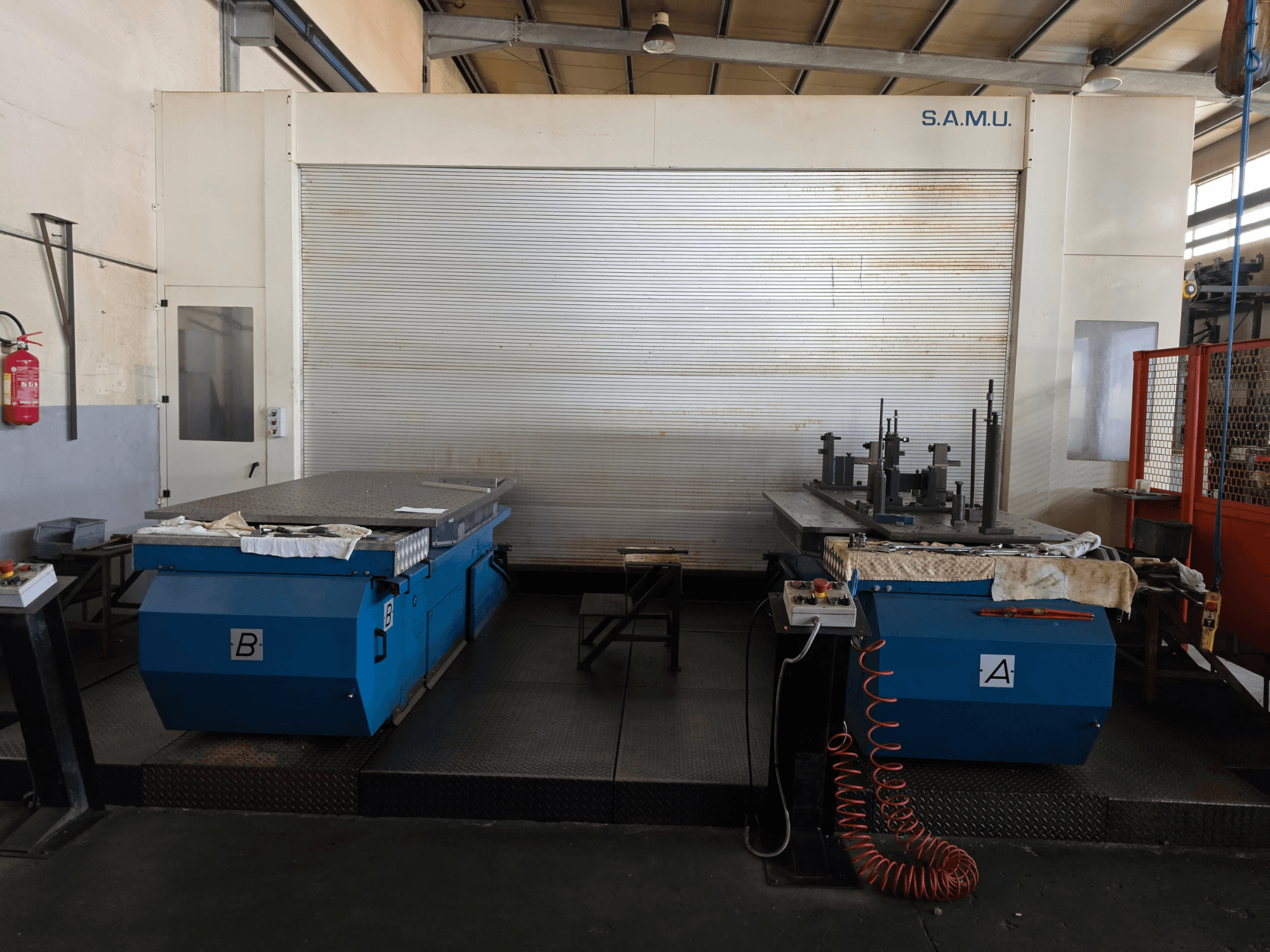 Das horizontale Bearbeitungszentrum Mandelli RS1500 U25 von vorne gesehen, mit zwei blauen Arbeitstischen, die mit A und B gekennzeichnet sind.