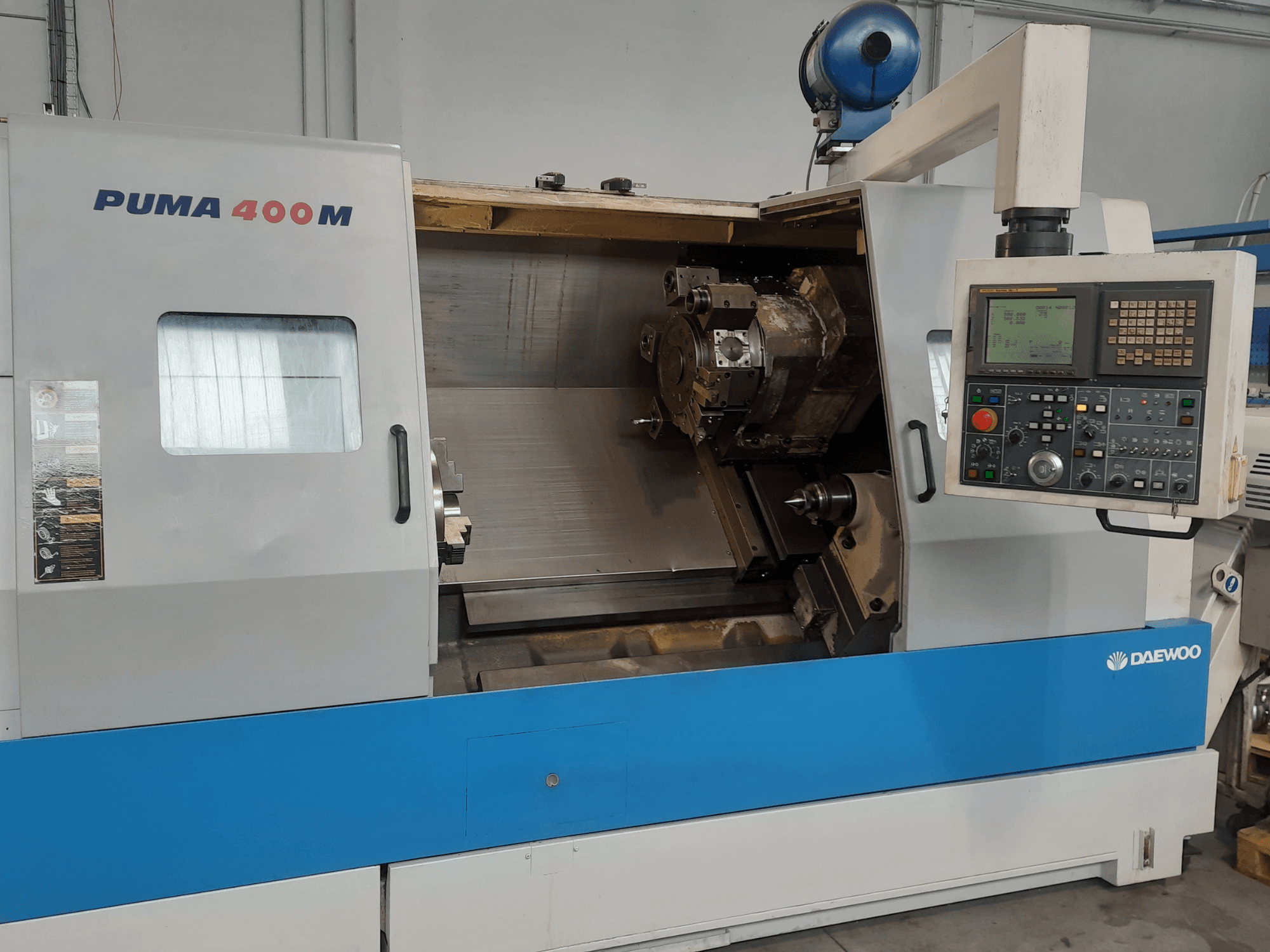 Vorderansicht einer horizontalen Drehmaschine vom Typ DAEWOO PUMA 400MB mit den Bedienelementen und dem Schneidwerkzeug in der Spindelkammer.