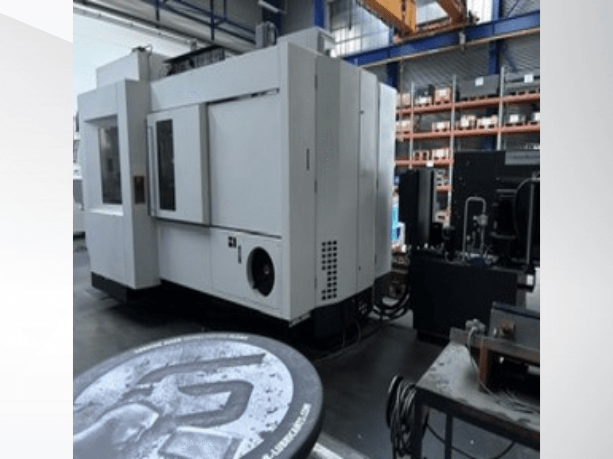 Weißes Universal-Bearbeitungszentrum MIKRON HPM 1350 U in einer Werkstatt, Seitenansicht mit großem Bedienfeld und industrieller Umgebung.