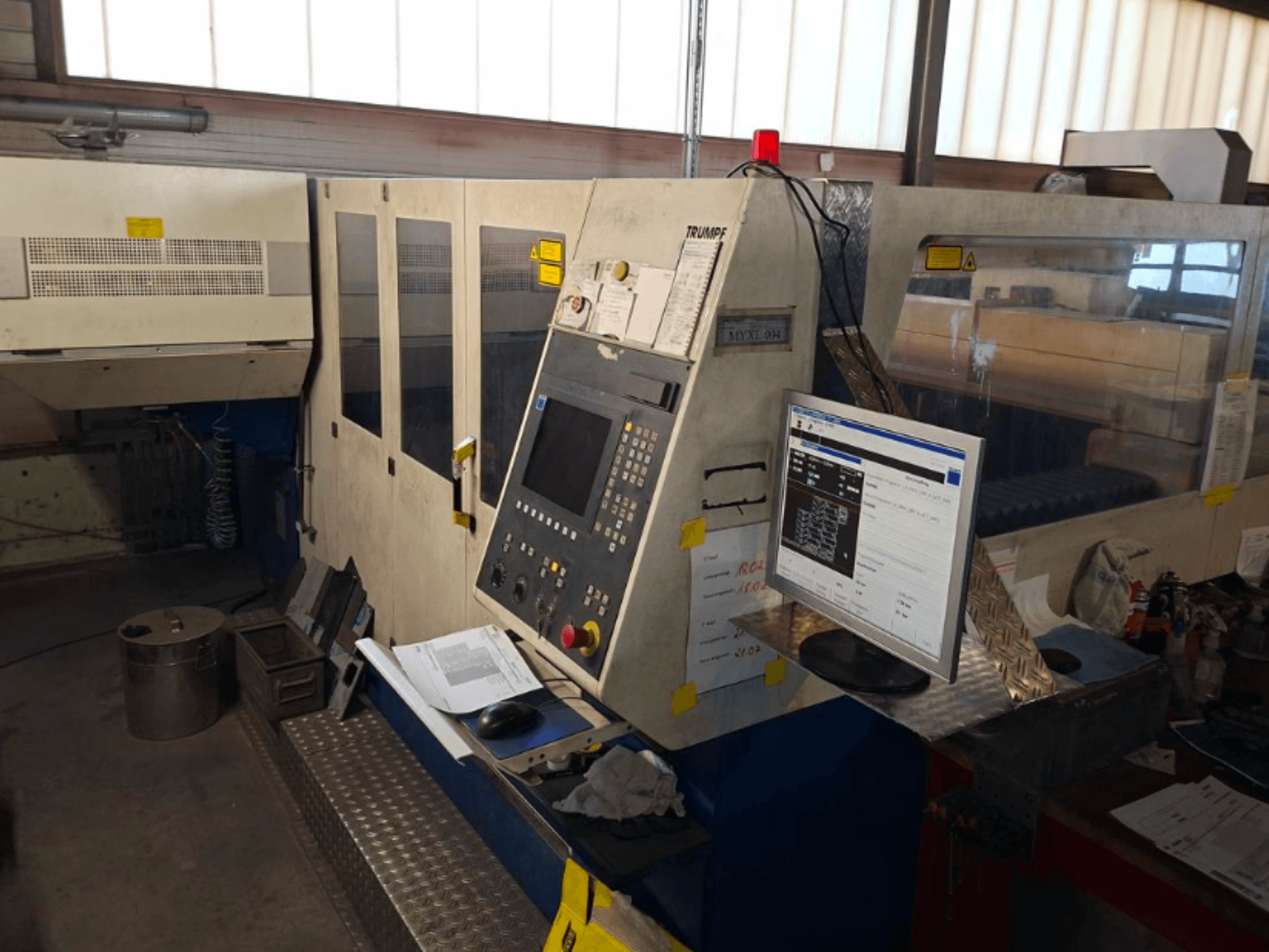 TRUMPF Trumatic L 4030 CO2-Laserschneidmaschine, Frontansicht mit Bedienfeld und Monitor, Details zum Arbeitsbereich sichtbar.