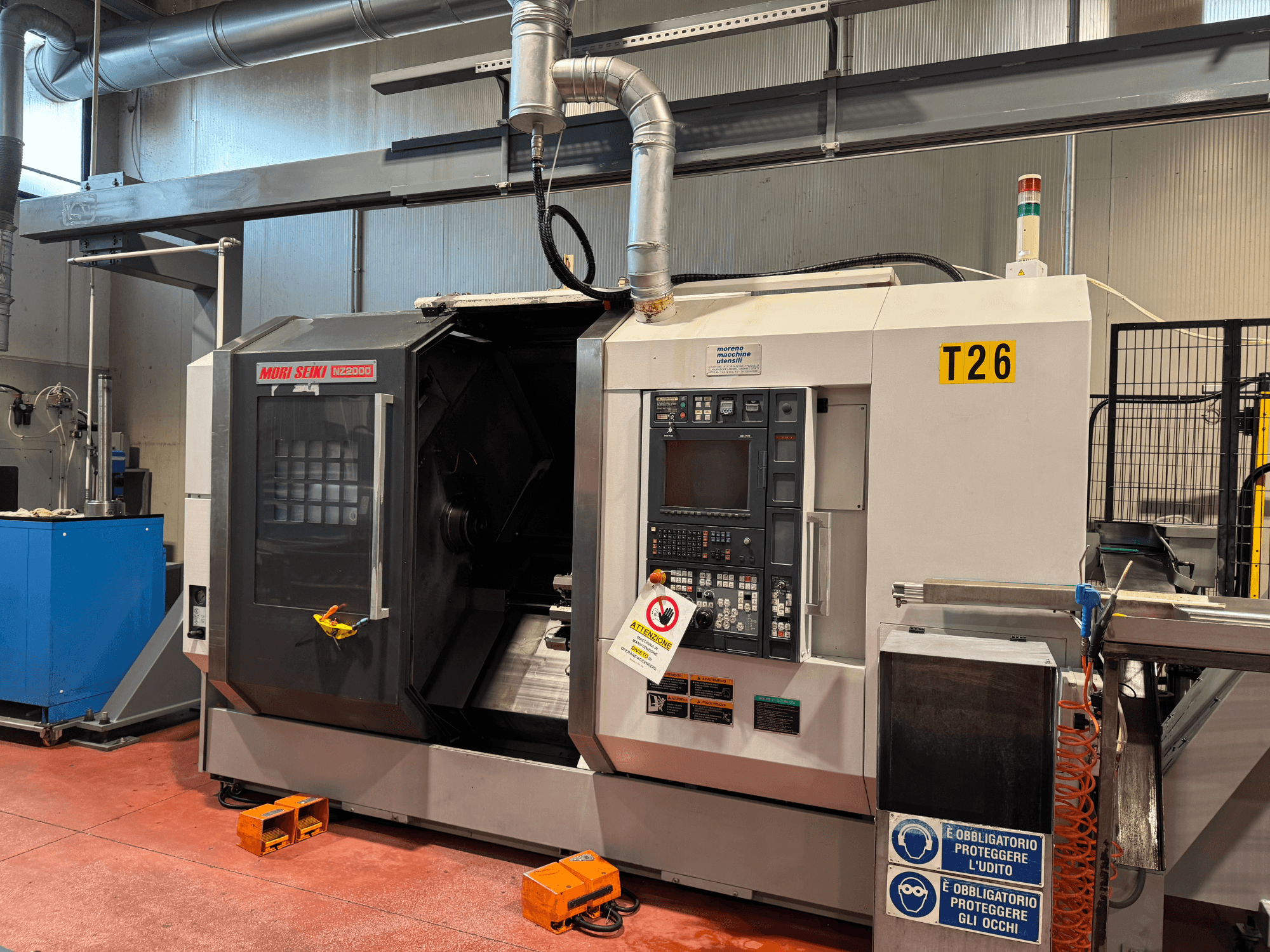 MORI SEIKI NZ-2000/T2/Y2 Dreh-Fräszentrum, Vorderansicht, mit Bedienfeld, Sicherheitsbeschilderung und industrieller Einrichtung.