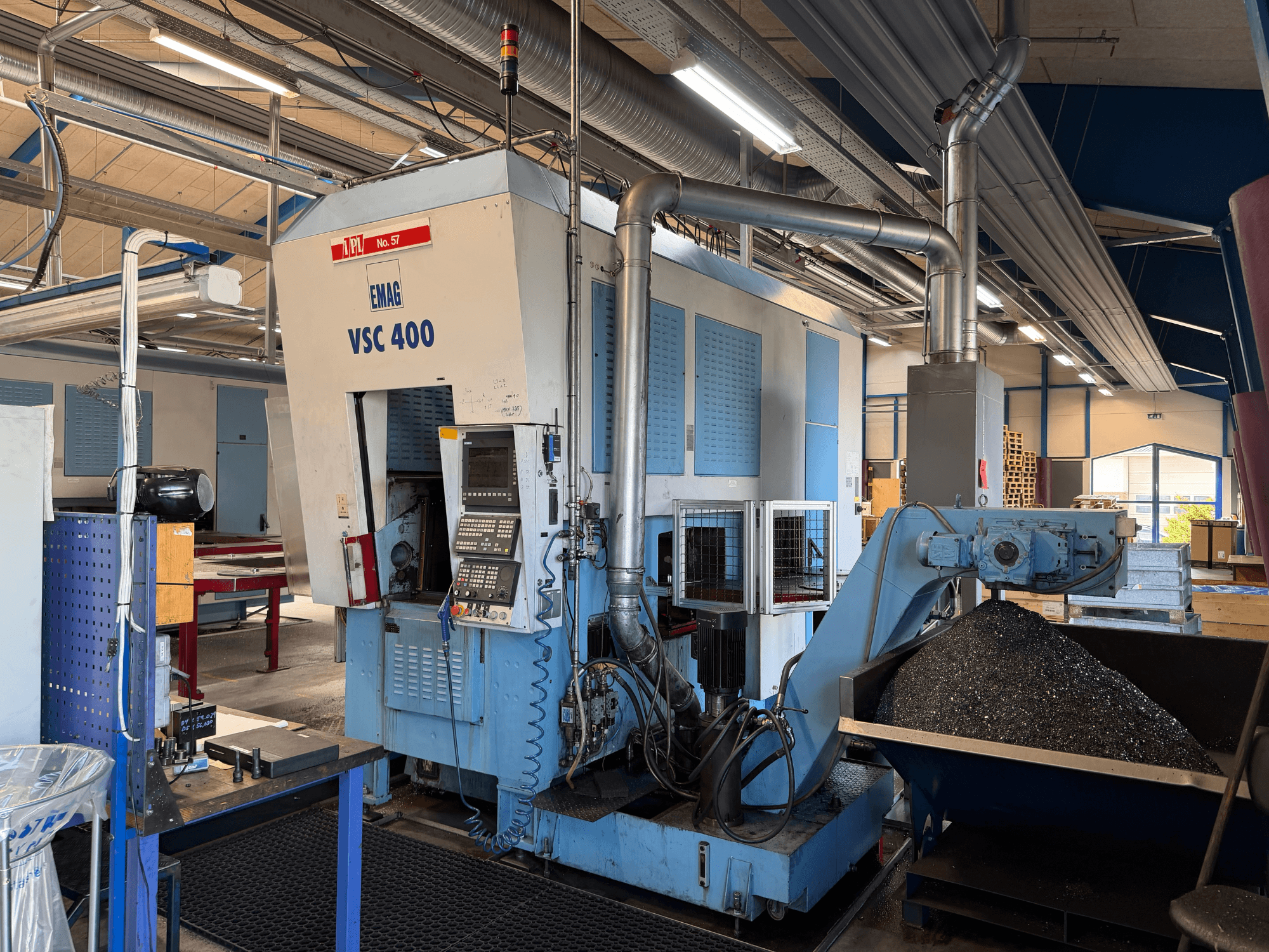 EMAG VSC 400 Vertikaldrehmaschine, Vorderansicht, mit Bedienfeld und Späneförderer. Industrielle Umgebung sichtbar.