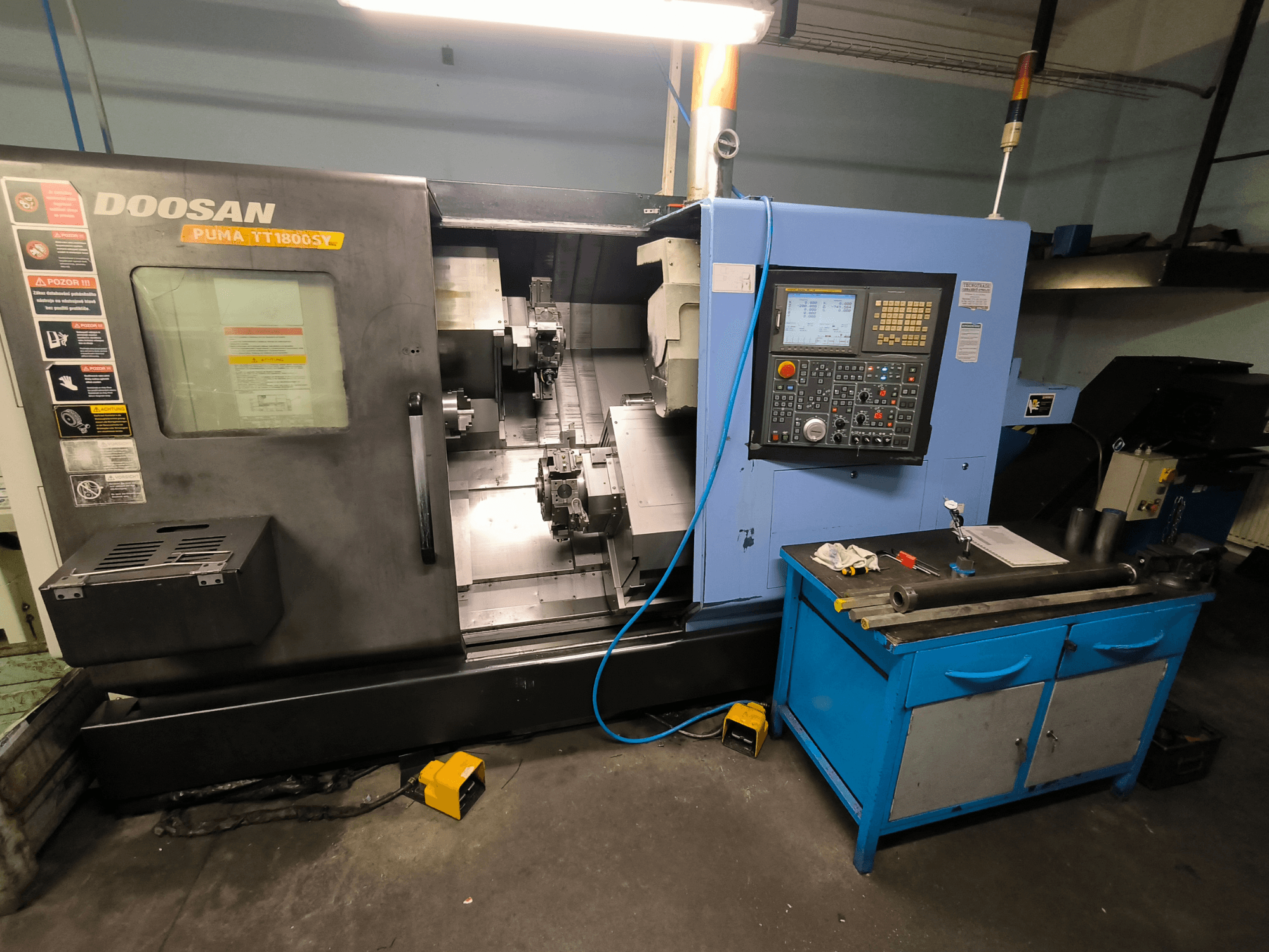 Doosan Puma TT1800SY CNC-Drehmaschine, Vorderansicht, mit Bedienfeld, Arbeitsbereich mit Werkzeugen und Maschinenkomponenten.