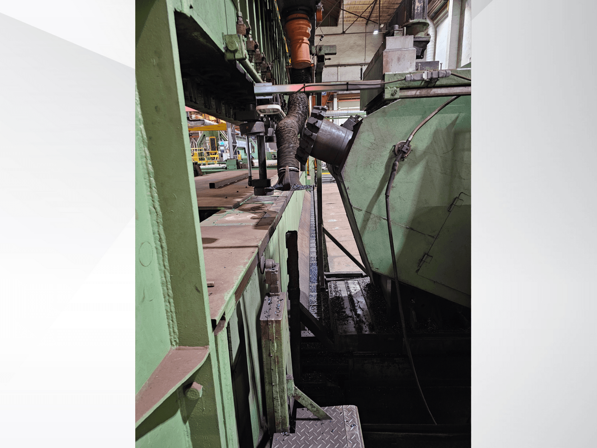 Grüne Industriemaschinen mit einer Seitenansicht eines Trichters und eines Zuführungsmechanismus, mit Metallkomponenten und einer Plattform.