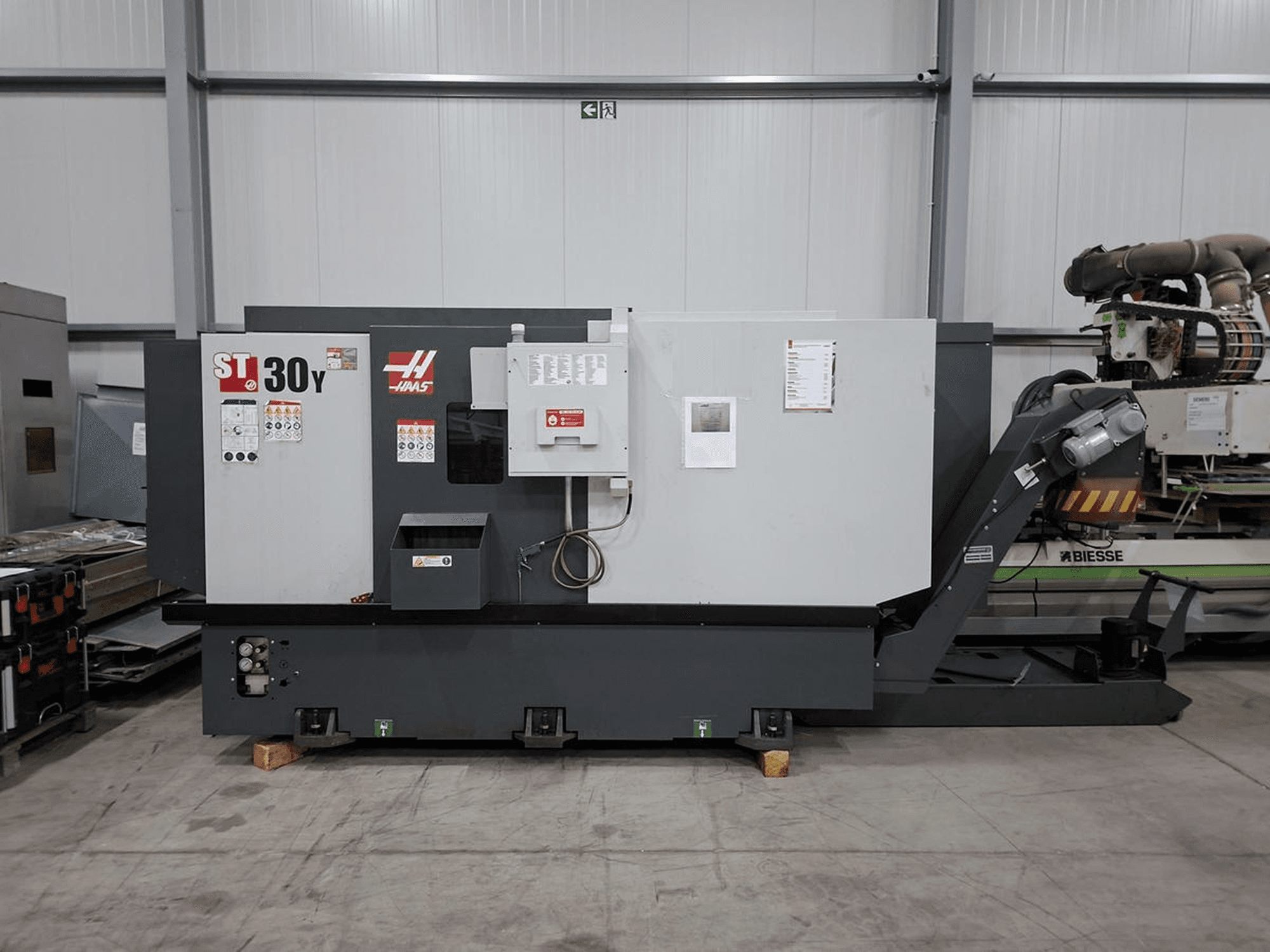 Horizontaldrehmaschine Haas ST-30Y in Seitenansicht, mit sichtbaren Bedienelementen, Beschriftungen und einer robusten Bauweise in einer geräumigen Werkstatt.
