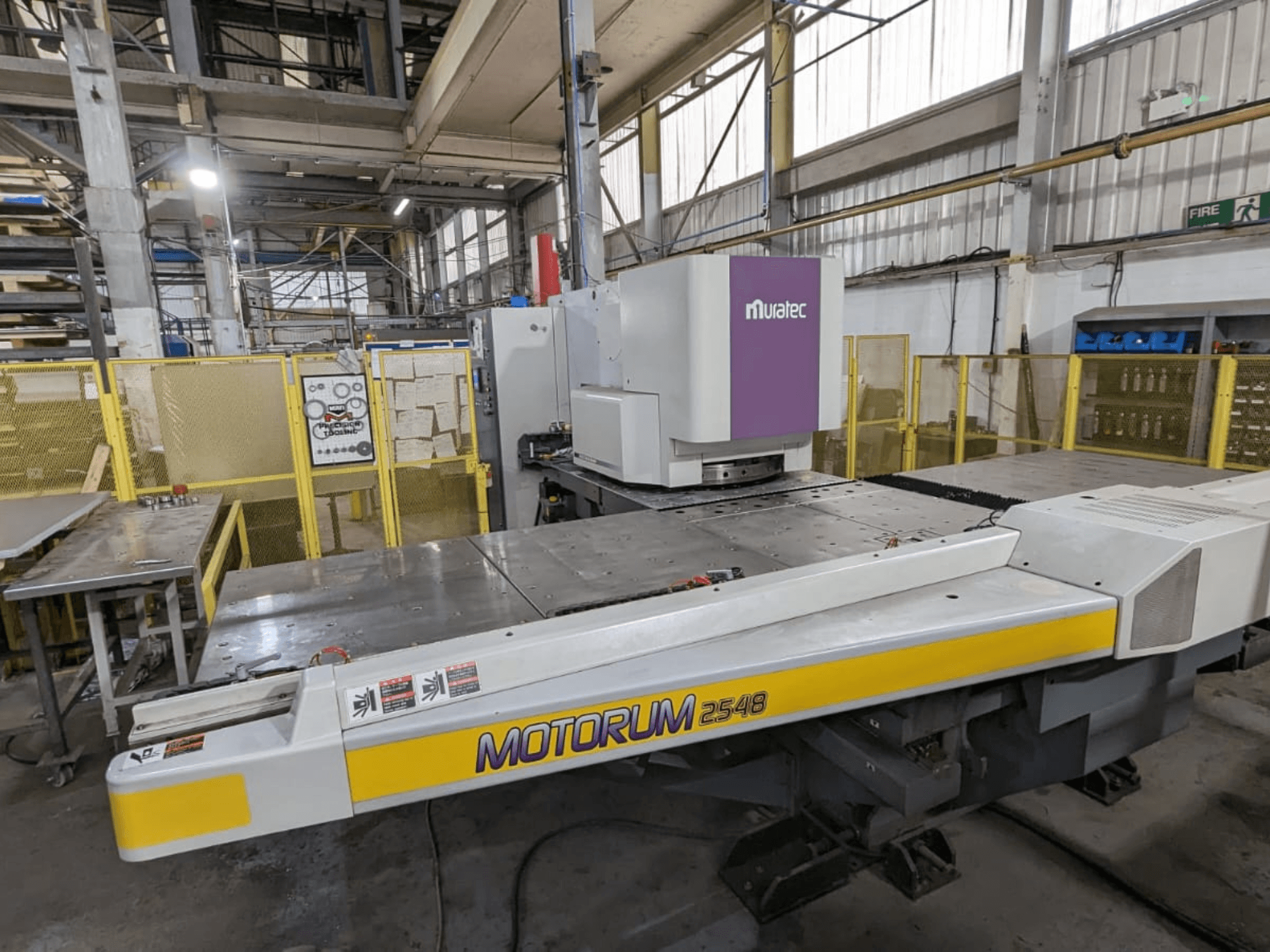 Muratec MOTORUM 2548 CNC-Stanzpresse, Vorderansicht mit Bedienfeld und Arbeitstisch in einer Fabrikumgebung.