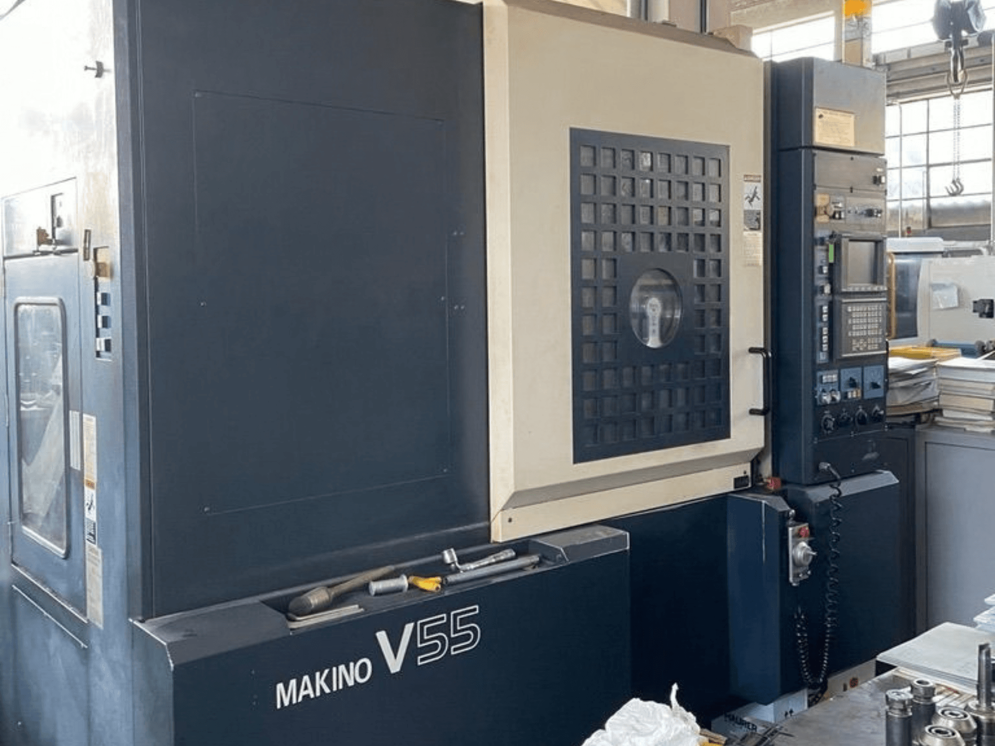 Vertikales Bearbeitungszentrum Makino V55-A15, Vorderansicht mit Bedienfeld, robuster Bauweise und Arbeitsbereichskonfiguration.