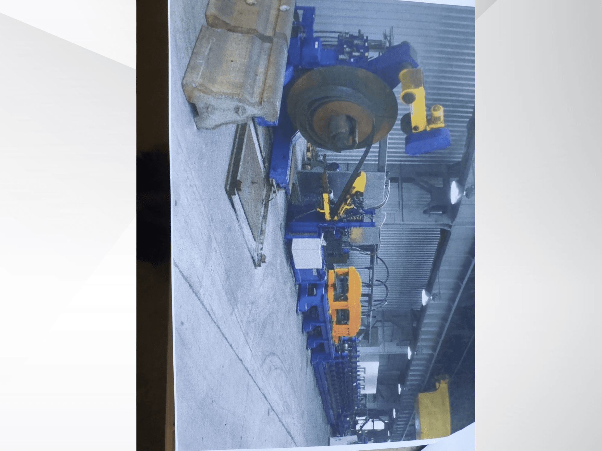 Eine Profilbiegemaschine vom Typ „Müller Profilierung 3“ in einer Werkstatt, die sich durch eine blaue Konstruktion und gelbe Hydraulikkomponenten auszeichnet.