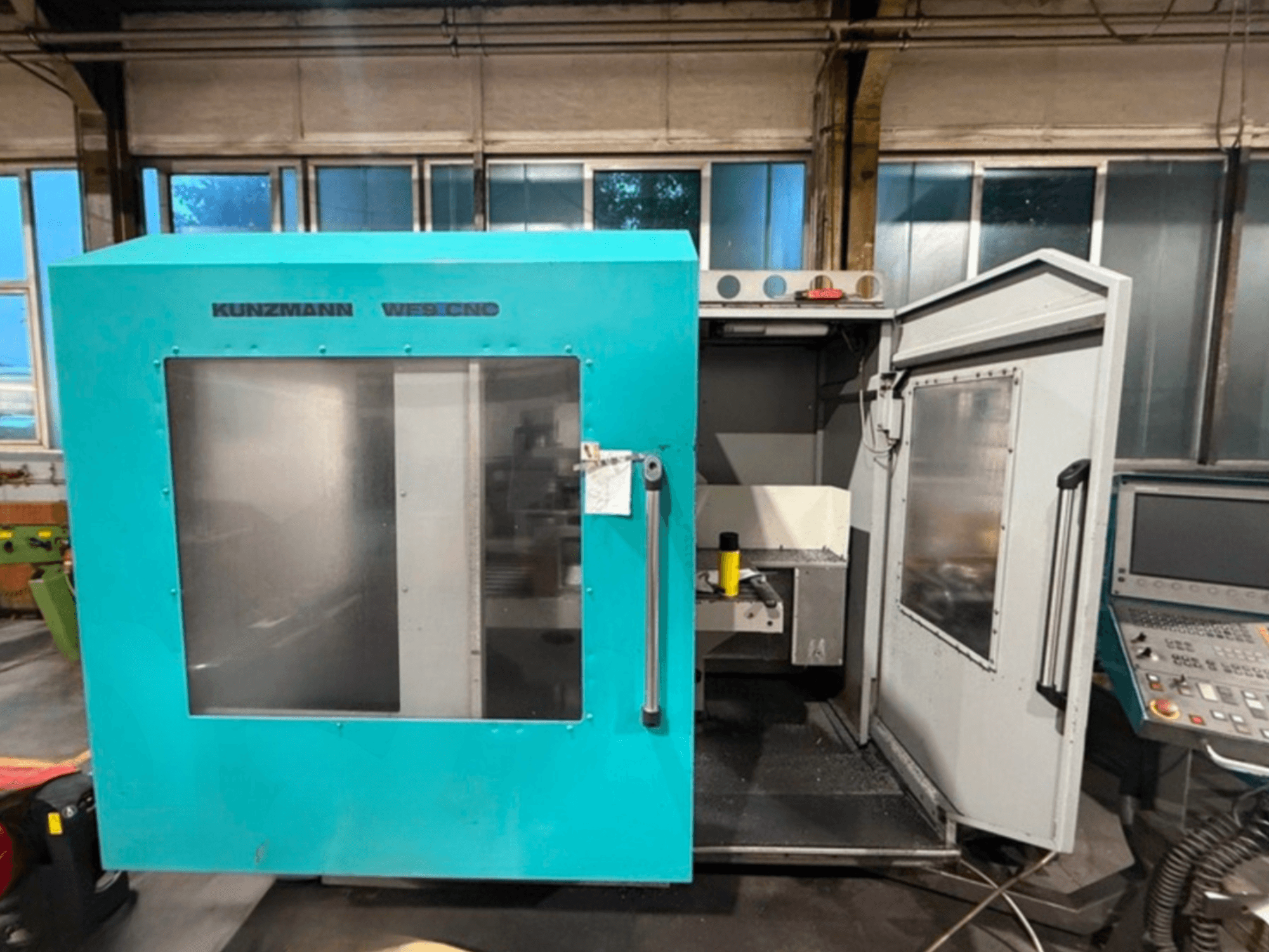 KUNZMANN WF9 CNC-Vertikal-Bearbeitungszentrum, Vorderansicht mit geöffneten Türen, die den Innenraum und das Bedienfeld zeigen.