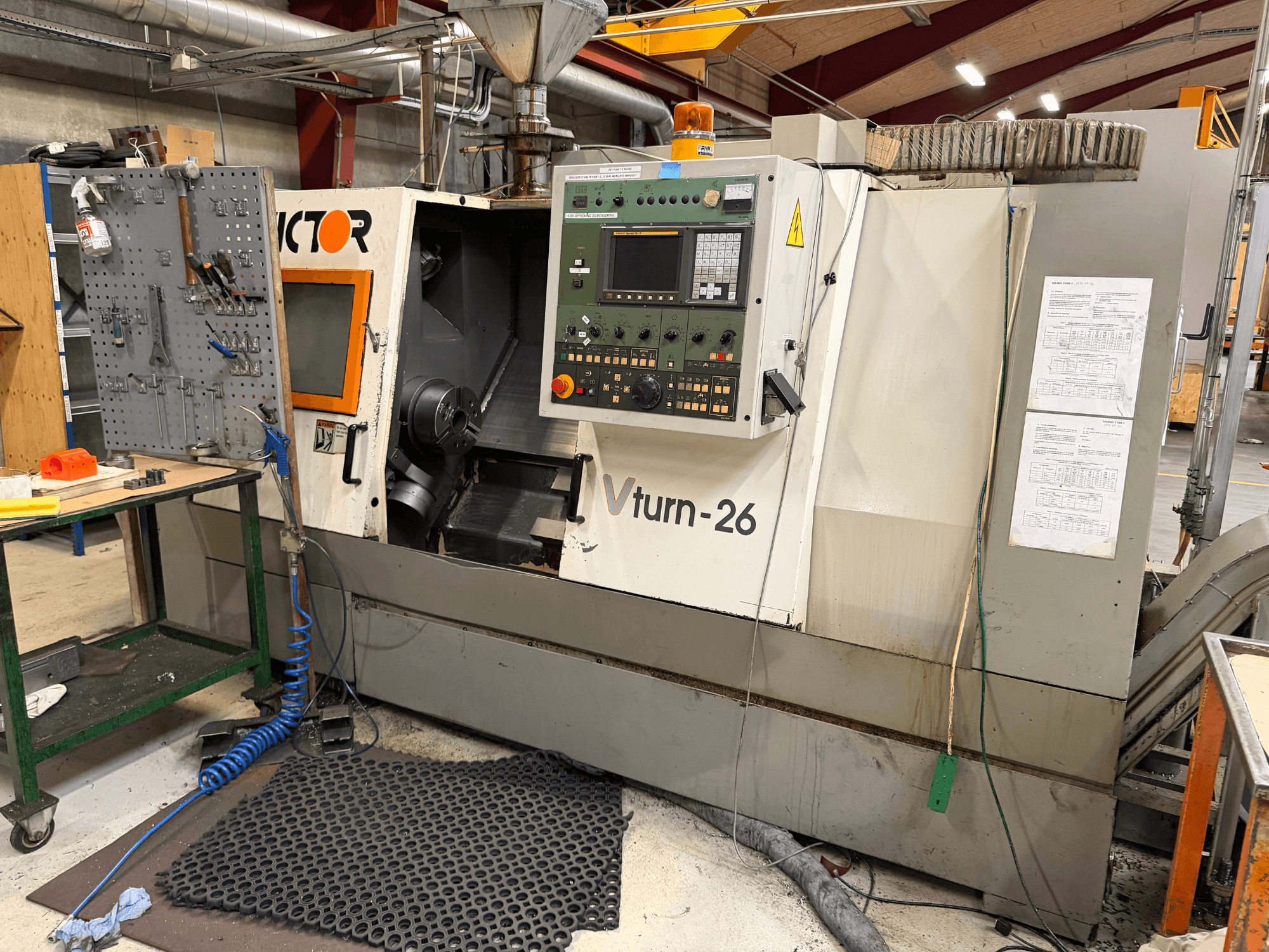 Die Horizontal-Drehmaschine Victor VTurn-26, Ansicht von vorne, zeigt das Bedienfeld und die Betriebskomponenten in einer Werkstattumgebung.