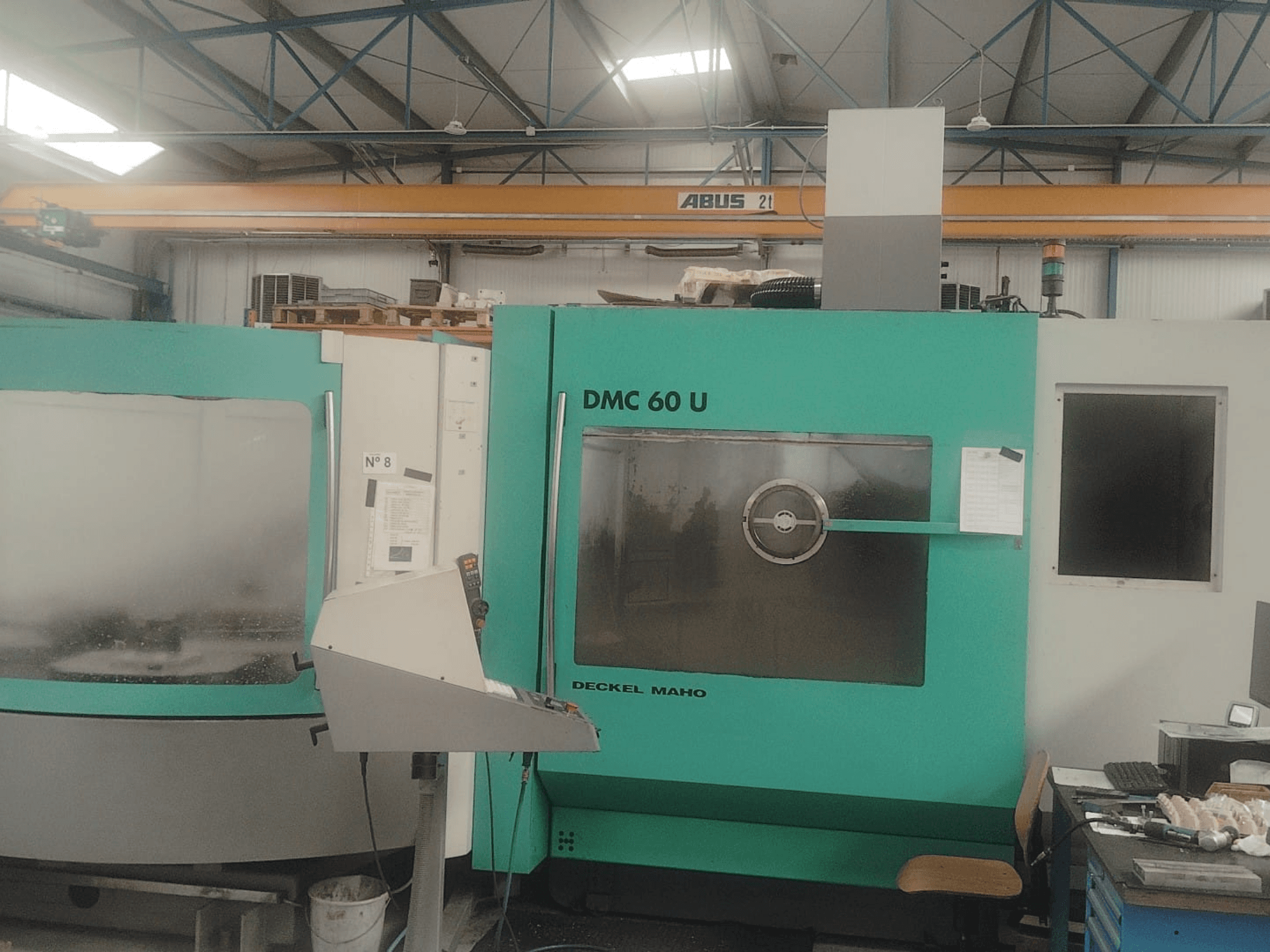 Frontansicht eines DECKEL MAHO DMC 60 U Mill-Turn Centers mit Bedienfeld und großem Glas-Sichtfenster.