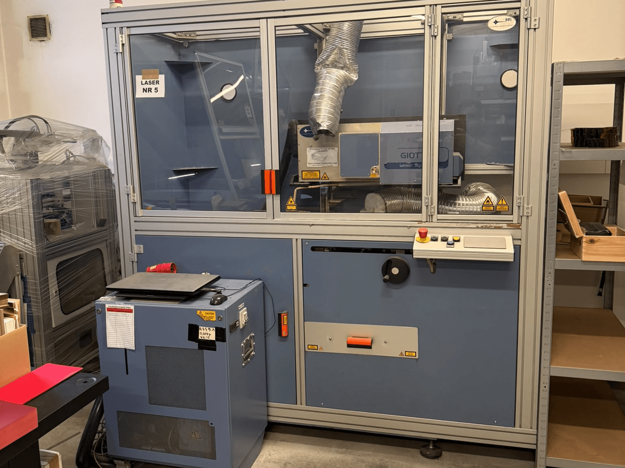 CO₂-Laserschneidmaschine von SEI Laser, Modell PAPER BLASTER 02, in der Vorderansicht mit Bedienfeld und Belüftungssystem.