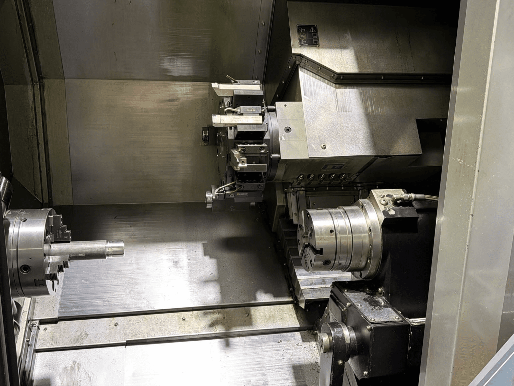 Innenansicht des Hurco TMX8MYS Dreh-Fräszentrums mit Spindel, Spannfutter und Werkzeughalter mit Metalloberflächen.