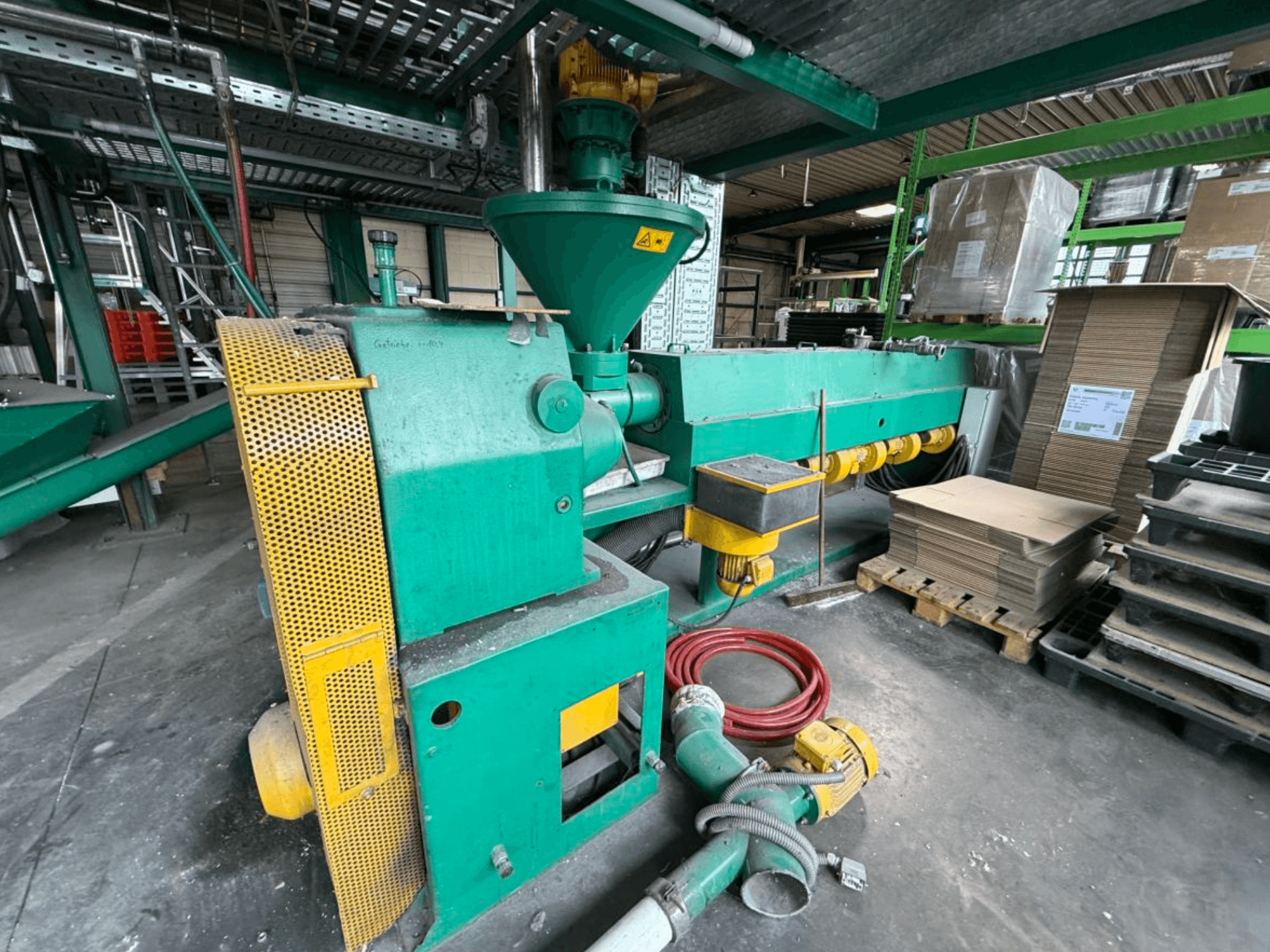 Einschneckenextruder „Prealpina 105“ von „Other“, dargestellt in Seitenansicht; mit grünem Gehäuse, Förderbandaufsätzen und angrenzenden Materialien.