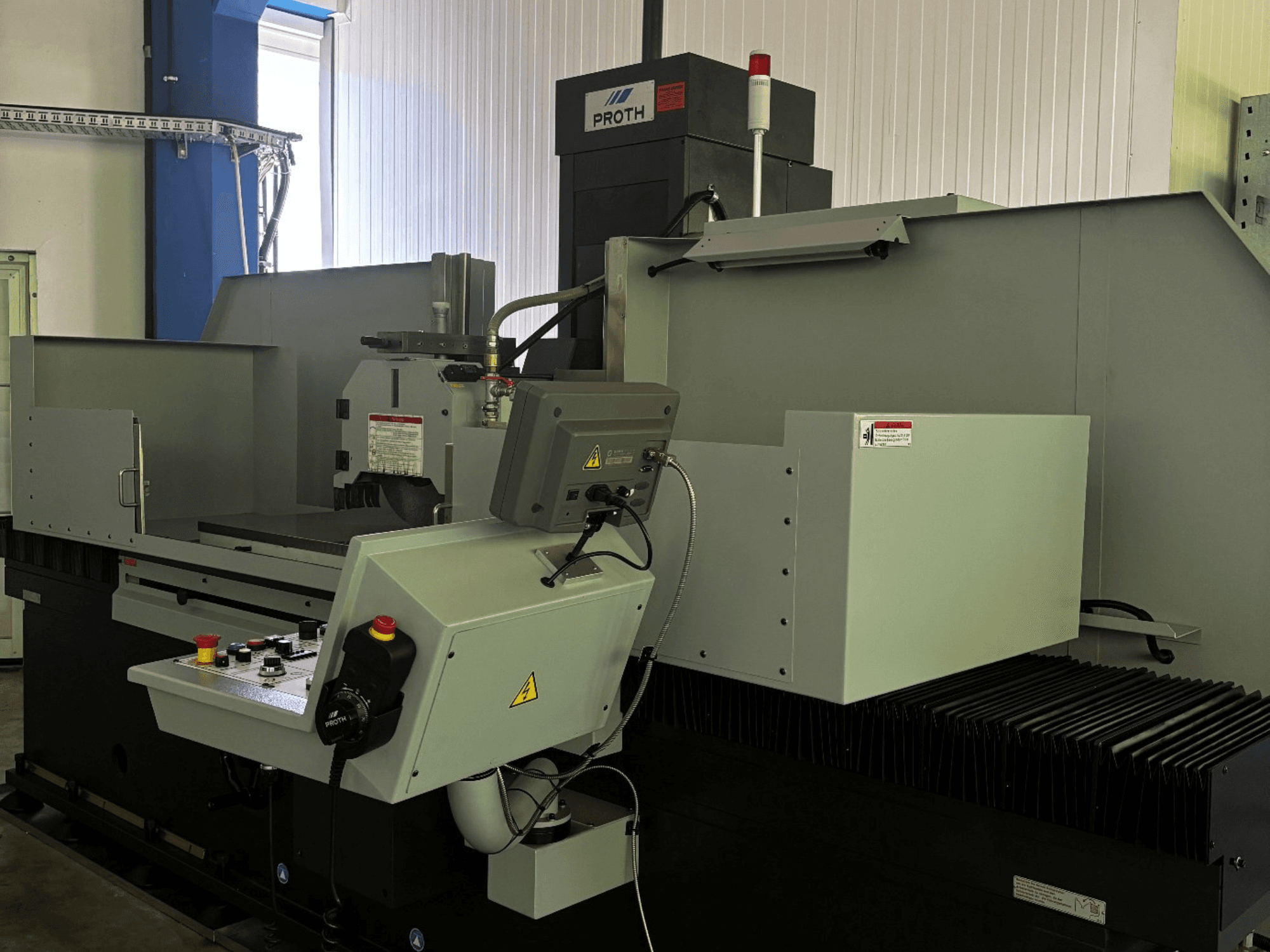 Flachschleifmaschine Proth PSGC-50120AHR, Vorderansicht, mit Blick auf das Bedienfeld und den Schleifscheibenbereich.