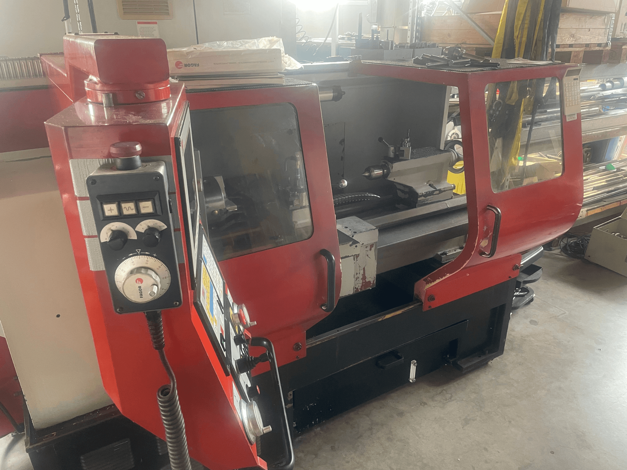 EMCO EMCOMAT 200X1000 Horizontal-Drehmaschine, Seitenansicht, mit Darstellung der Bedienelemente, der verglasten Schutzhaube und des Drehmaschinenaufbaus.
