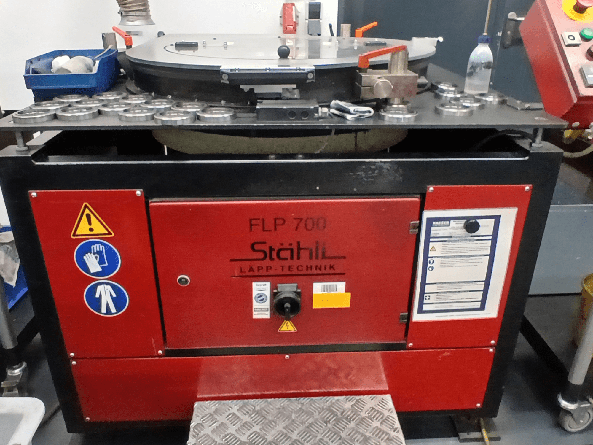 STAHLI FLP 700 Werkzeugmaschine, Vorderansicht, mit Bedienelementen, Sicherheitshinweisen und Komponenten auf einer Metalloberfläche.
