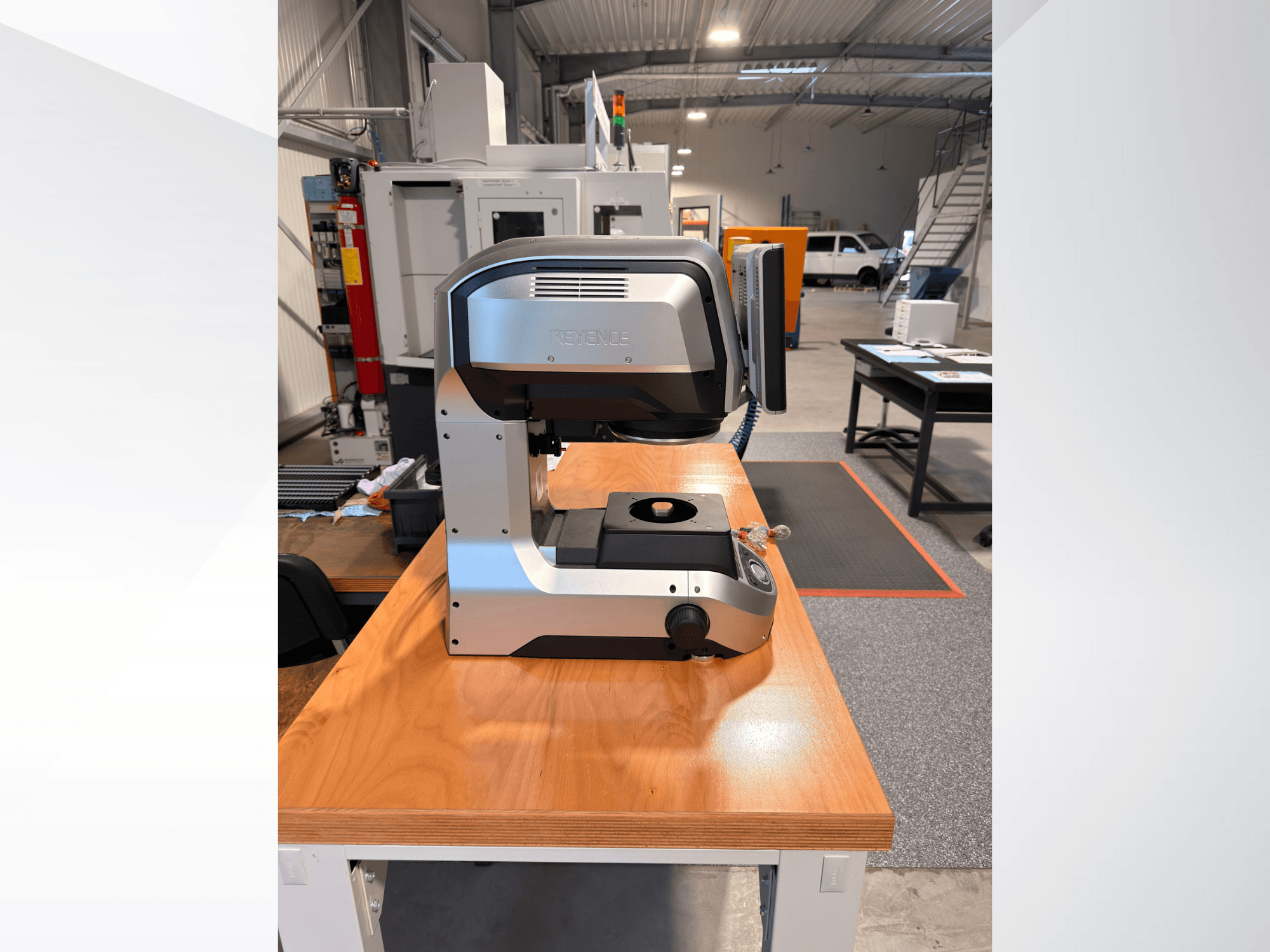 Vorderansicht der optischen Messmaschine IM-8005 von KEYENCE auf einem Holztisch, die ihr elegantes Design und ihre Bedienoberfläche zeigt.