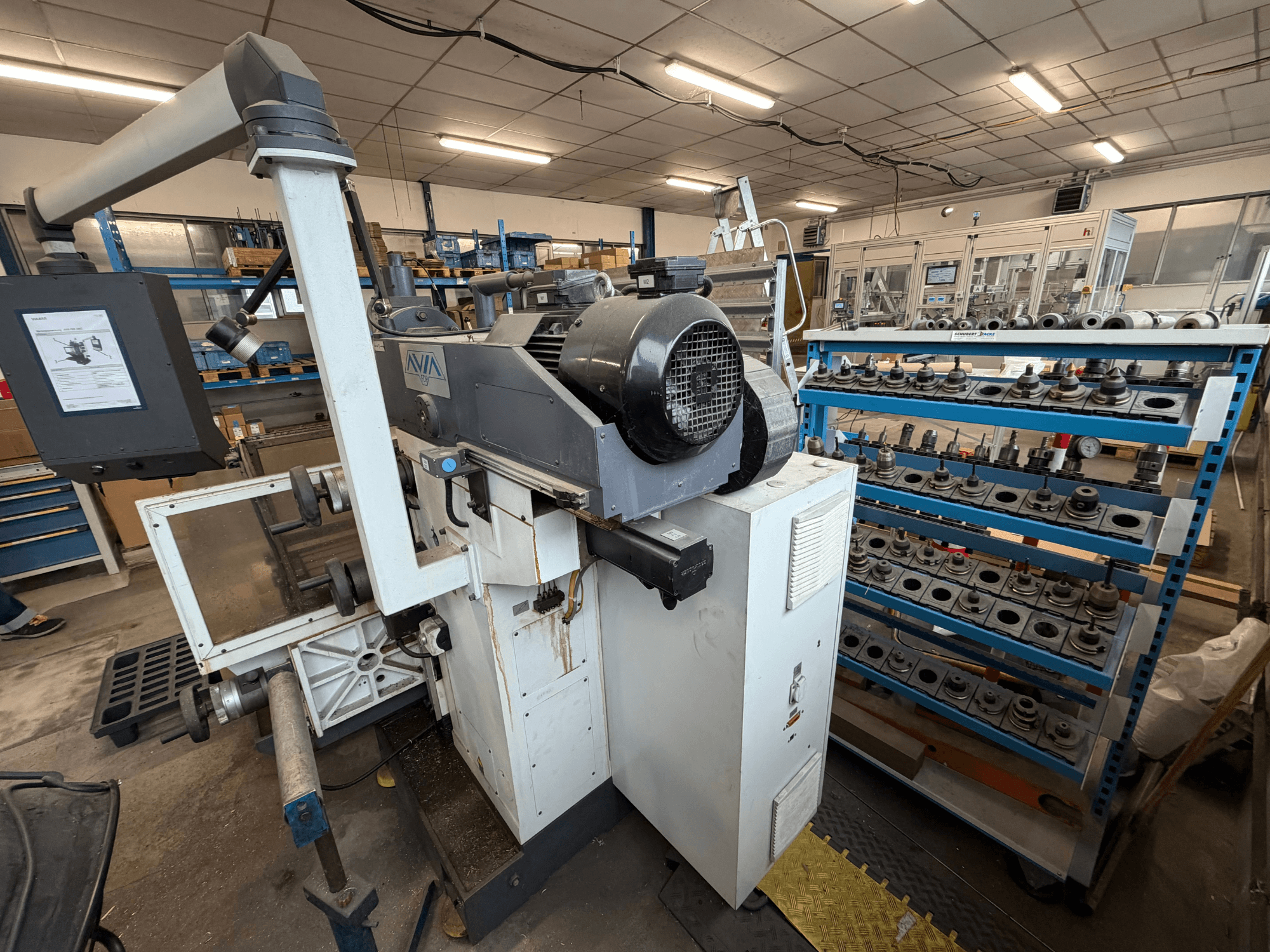 Avia FNX30NC Universal-Bearbeitungszentrum, Vorderansicht mit Bedienelementen und Werkzeuglagerbereich, im Hintergrund sind Komponenten zu sehen.