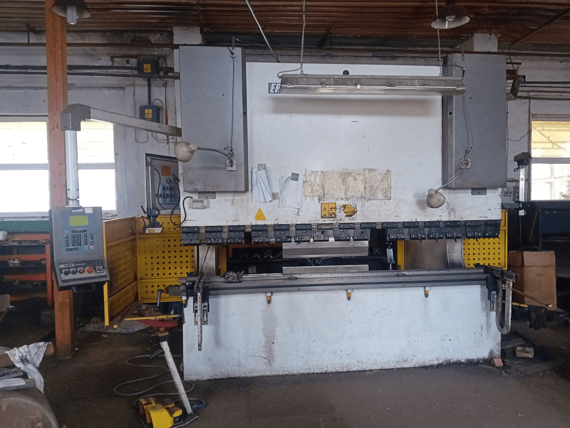 ERMAK CNC-Hydraulikpresse HAP 3100x300 in der Vorderansicht, mit Bedienpult und Werkbank in einer Werkstattumgebung.