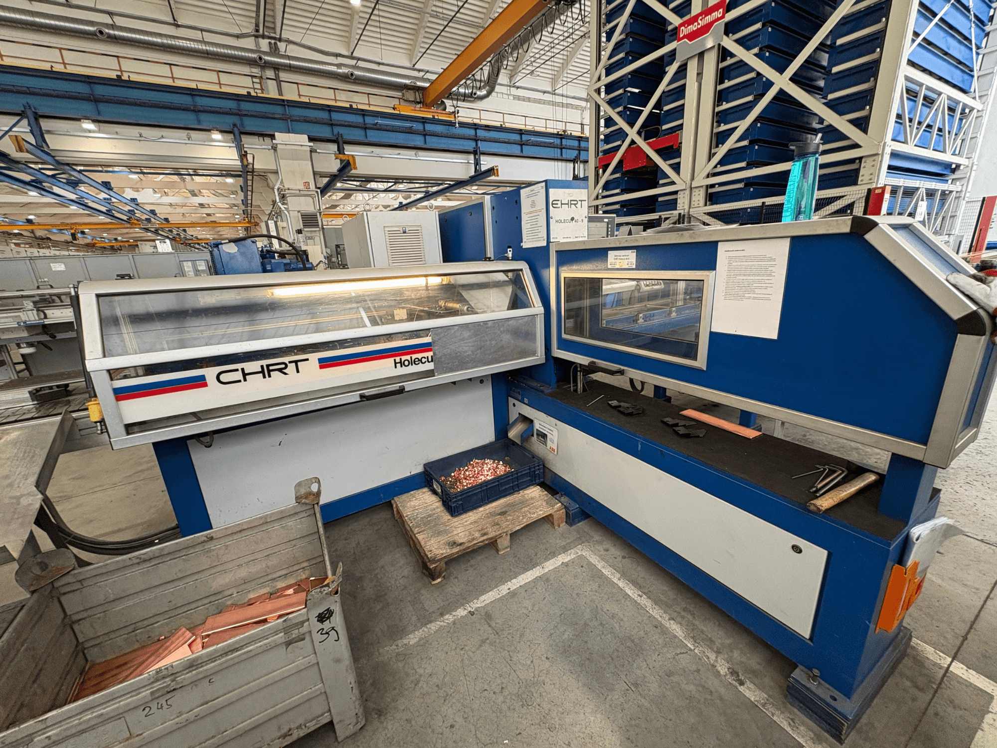 CNC-Stanzmaschine EHRT Holecut 40-9, Vorderansicht, mit Bedienfeld, Metallbehälter und Kupferblechen daneben.