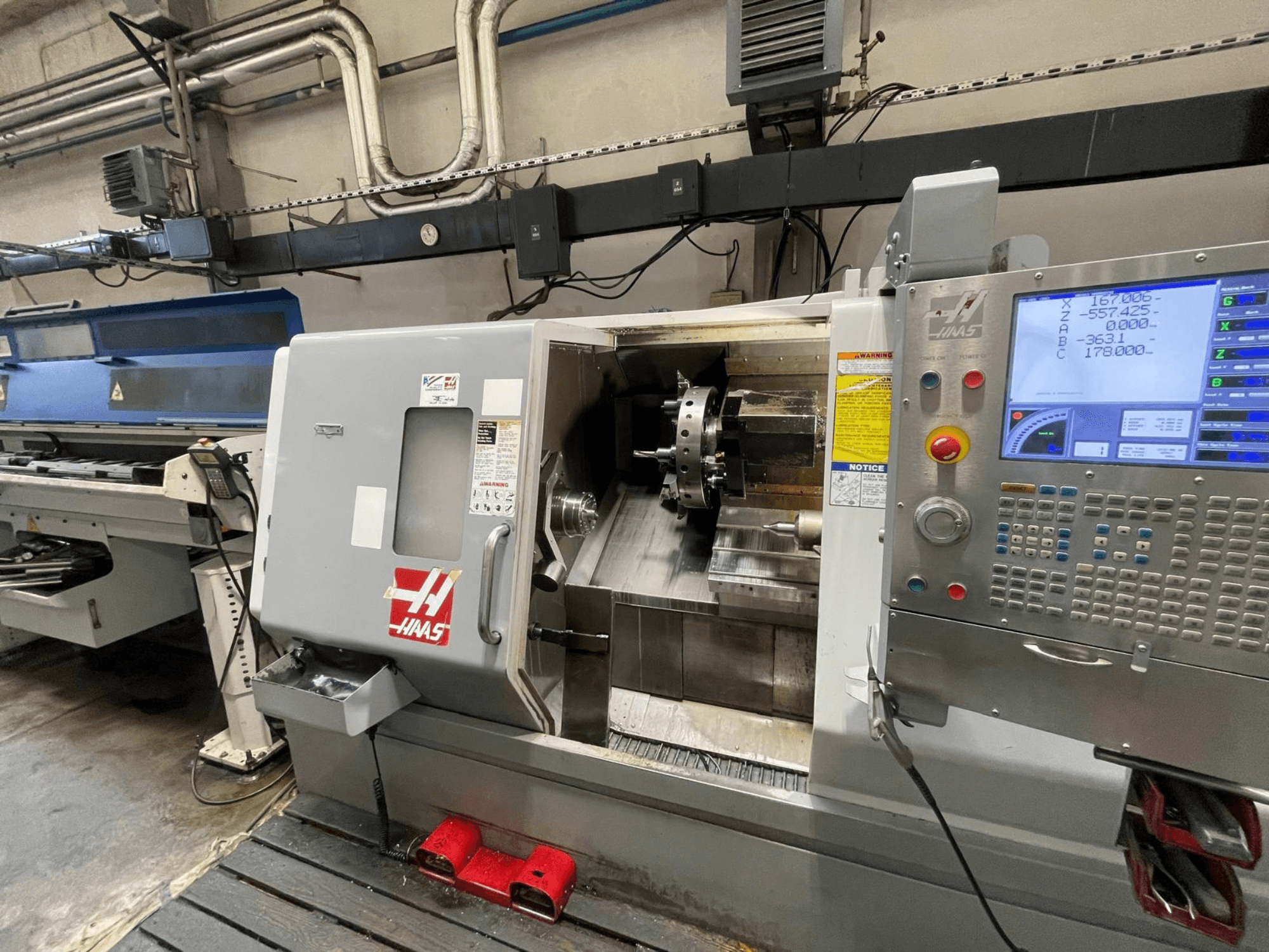 Die horizontale Drehmaschine Haas SL-30THE in einer Werkstatt, ausgestattet mit einem digitalen Bedienfeld und einem frei einsehbaren Arbeitsbereich.