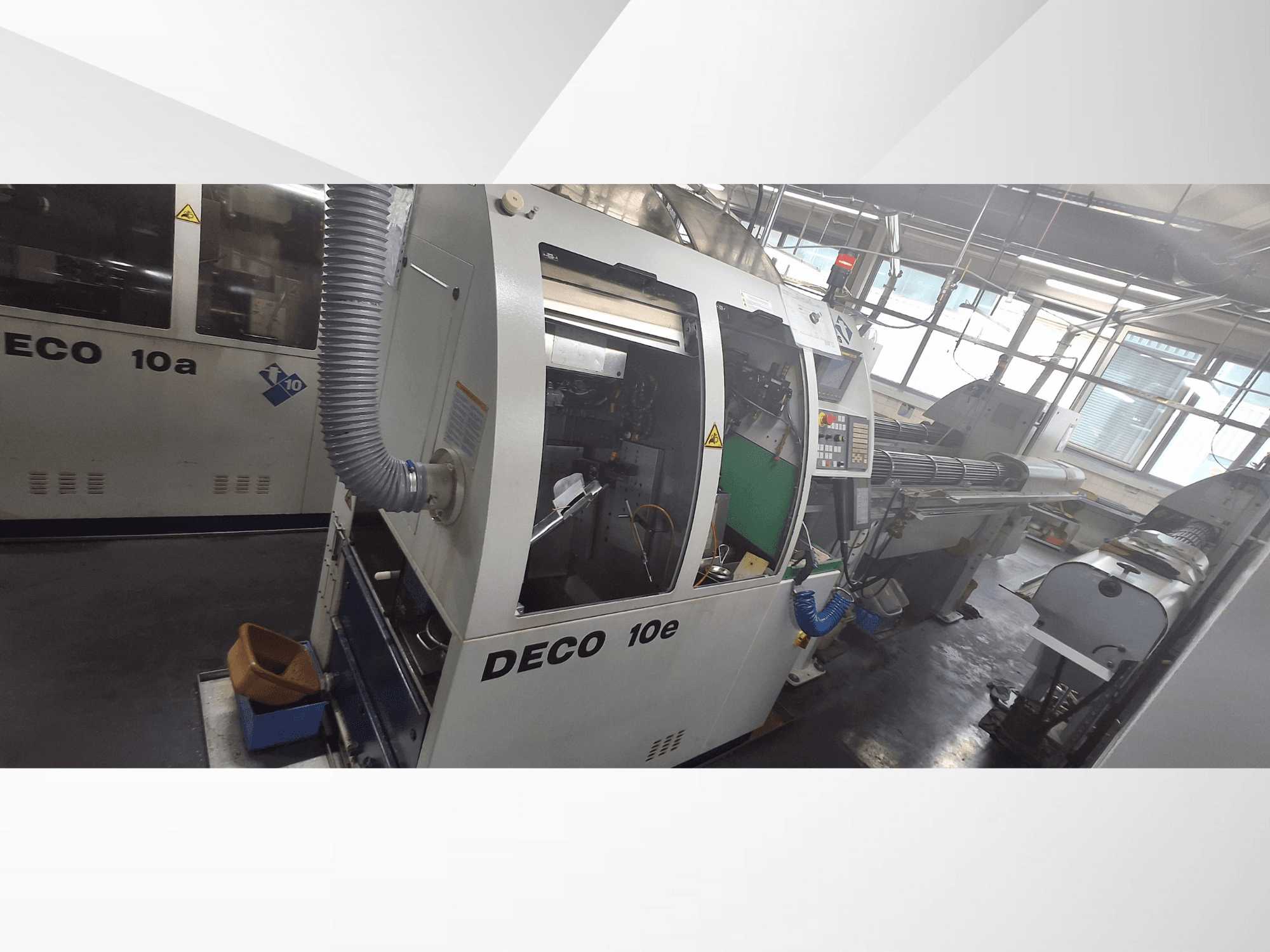CNC-Maschine DECO 10e in der Seitenansicht, mit Bedienfeld, grünem Innenraum und angeschlossenem Abluftschlauch.