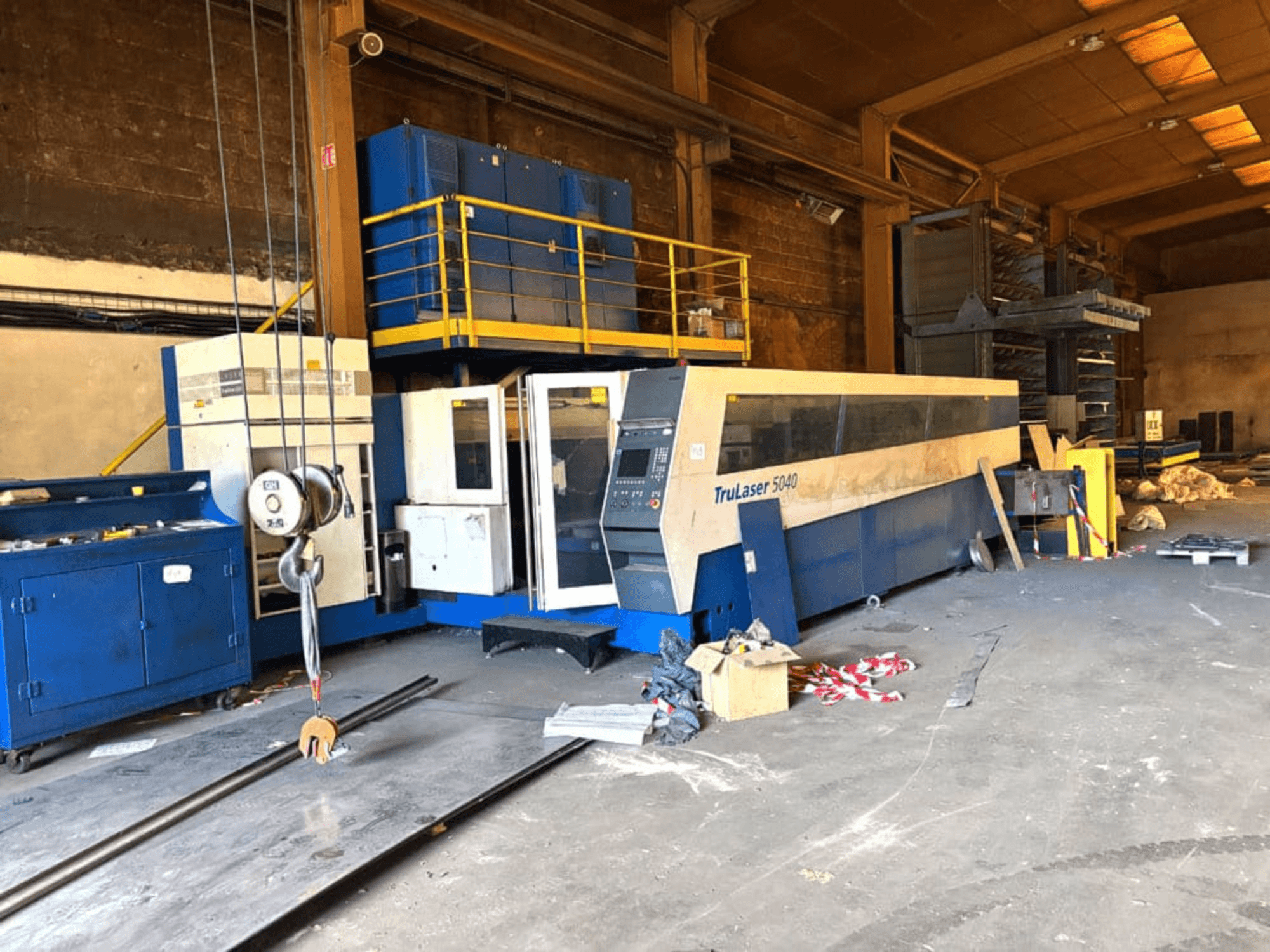 CO₂-Laserschneidmaschine von TRUMPF, Modell TRULASER 5040, aufgenommen in einer Werkstatt, schräge Vorderansicht vor einem unübersichtlichen Hintergrund.
