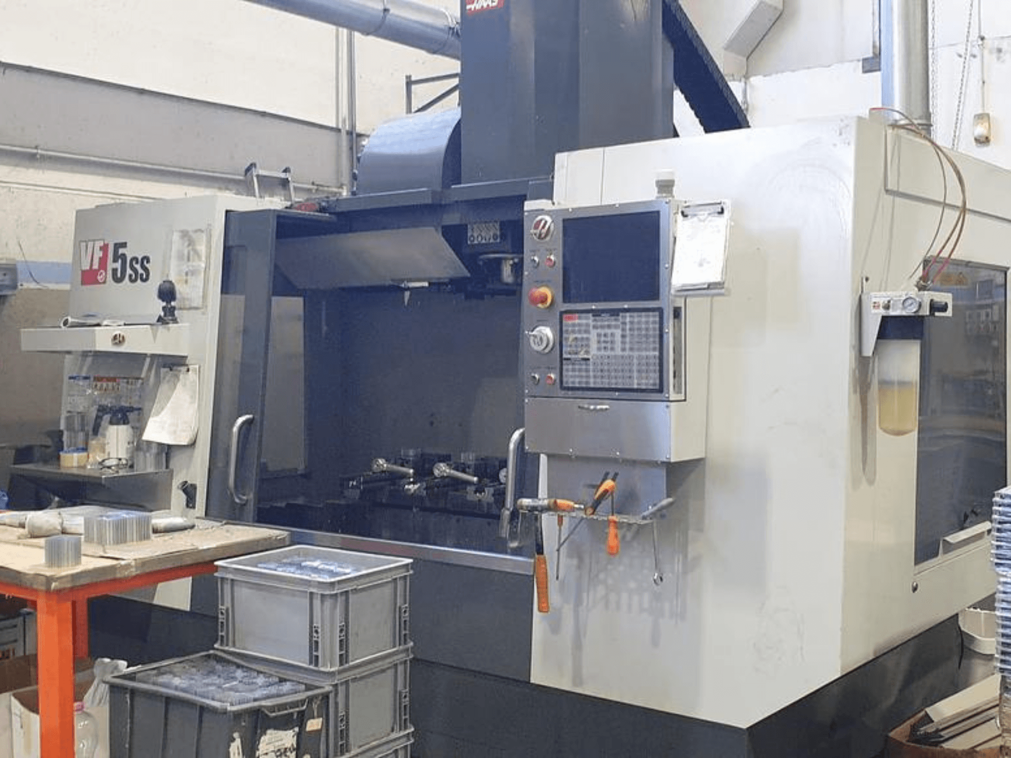 HAAS VF-5SS Vertikal-Bearbeitungszentrum in der Vorderansicht, mit Bedienfeld, Arbeitsbereich und Ablagefächern.