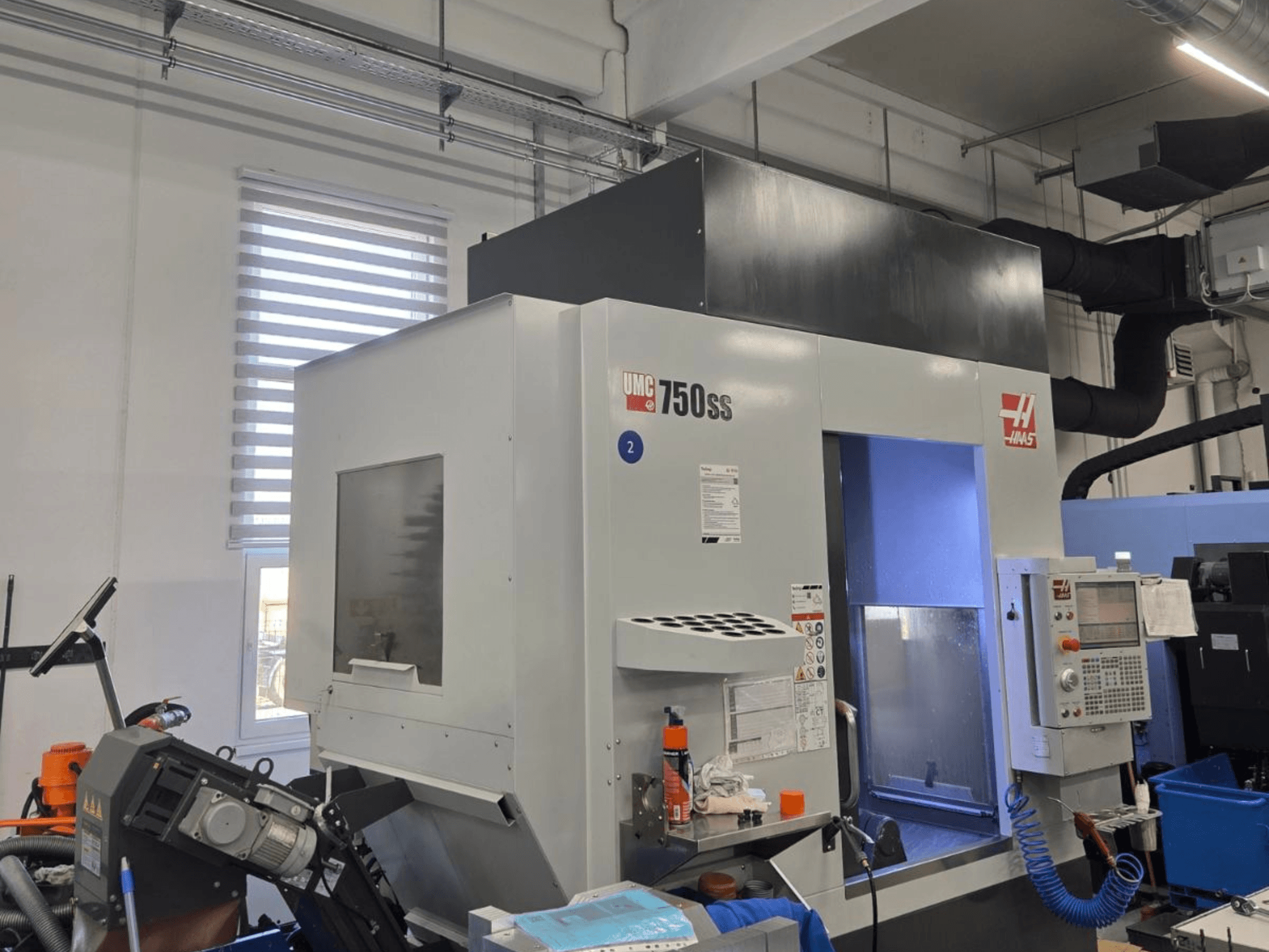 Vertikales Bearbeitungszentrum Haas UMC-750SS, Vorderansicht, mit Bedienfeld und freiem Zugang zum Bearbeitungsbereich.
