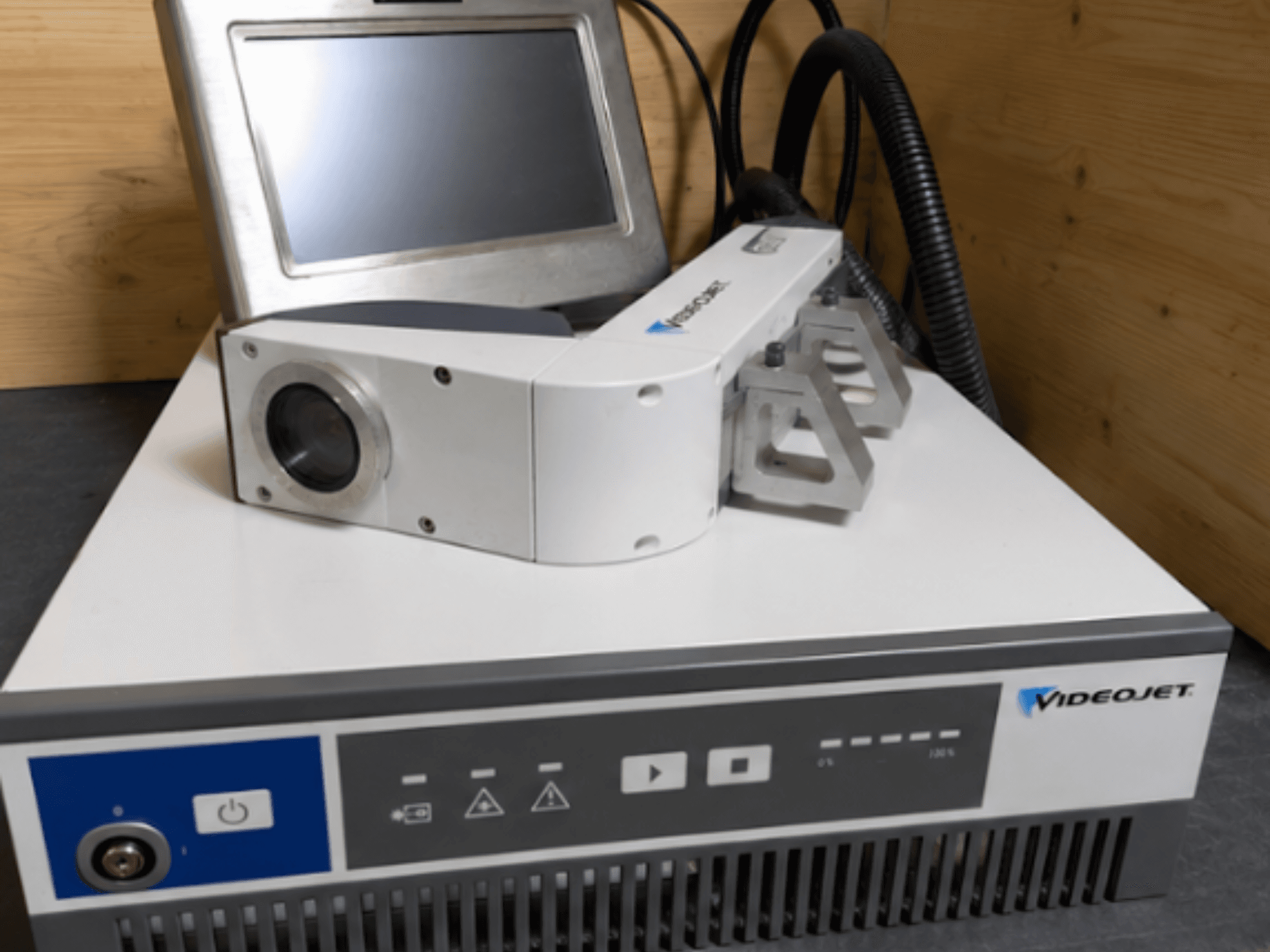 Videojet 7230 Lasergraviermaschine, Vorderansicht, zeigt Bedienfeld und Laserkopf mit Objektiv und Aufsatz.