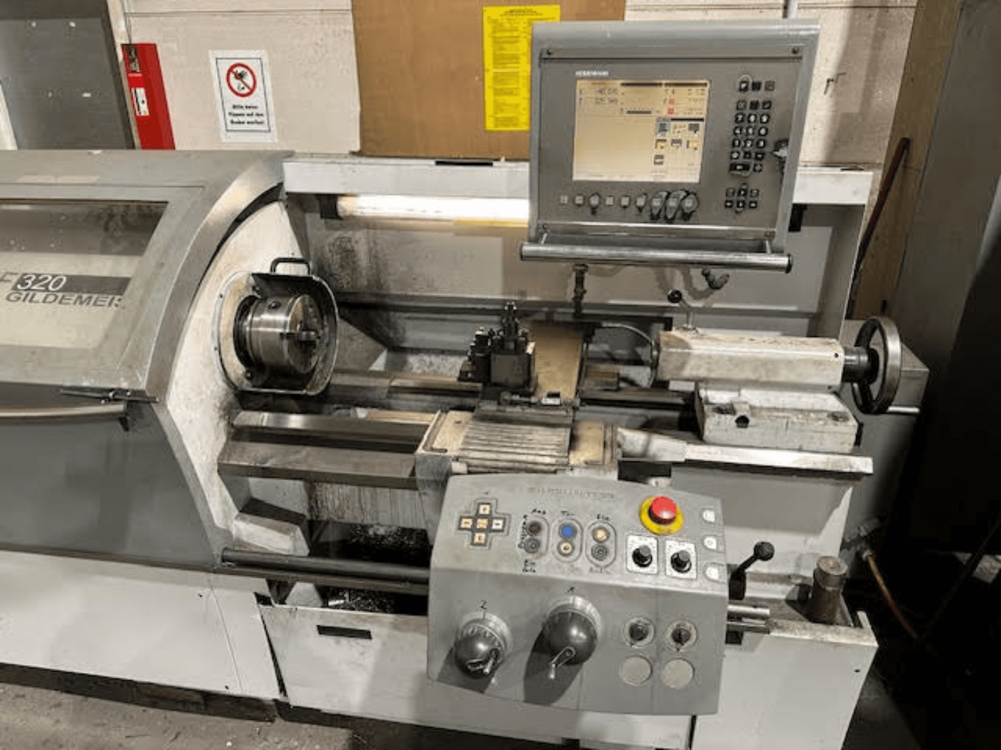 HERMLE NEF 320 Horizontal-Drehmaschine, Vorderansicht mit Bedienfeld, Werkzeugbereich und eingespanntem Metallwerkstück.