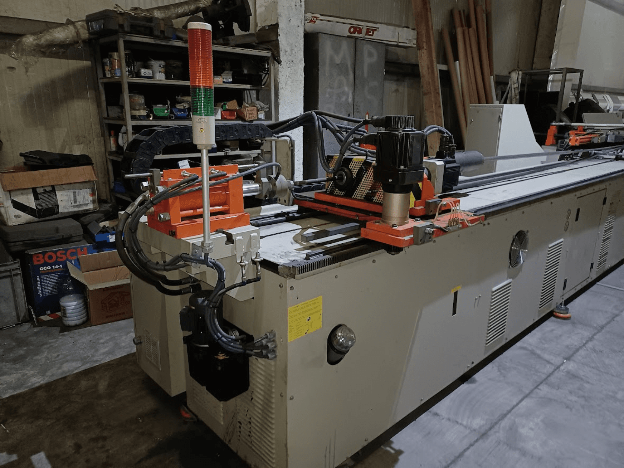 Abkantpresse CANSA CNC 51 R1, Seitenansicht, mit Blick auf das Bedienfeld, den Motor und die Kontrollleuchten in einer Werkstattumgebung.