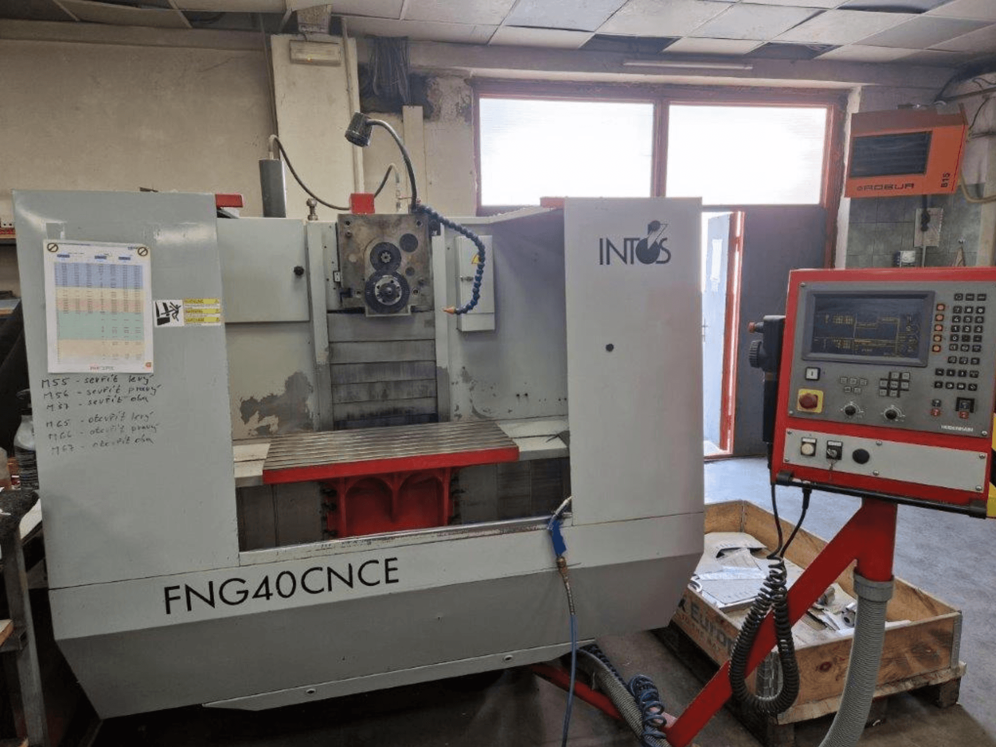 INTOS FNG40CNC Maschine, Vorderansicht, mit Bedienfeld, Funktionsteilen und einem Arbeitstisch aus Metall. Ideal für die Bearbeitung.