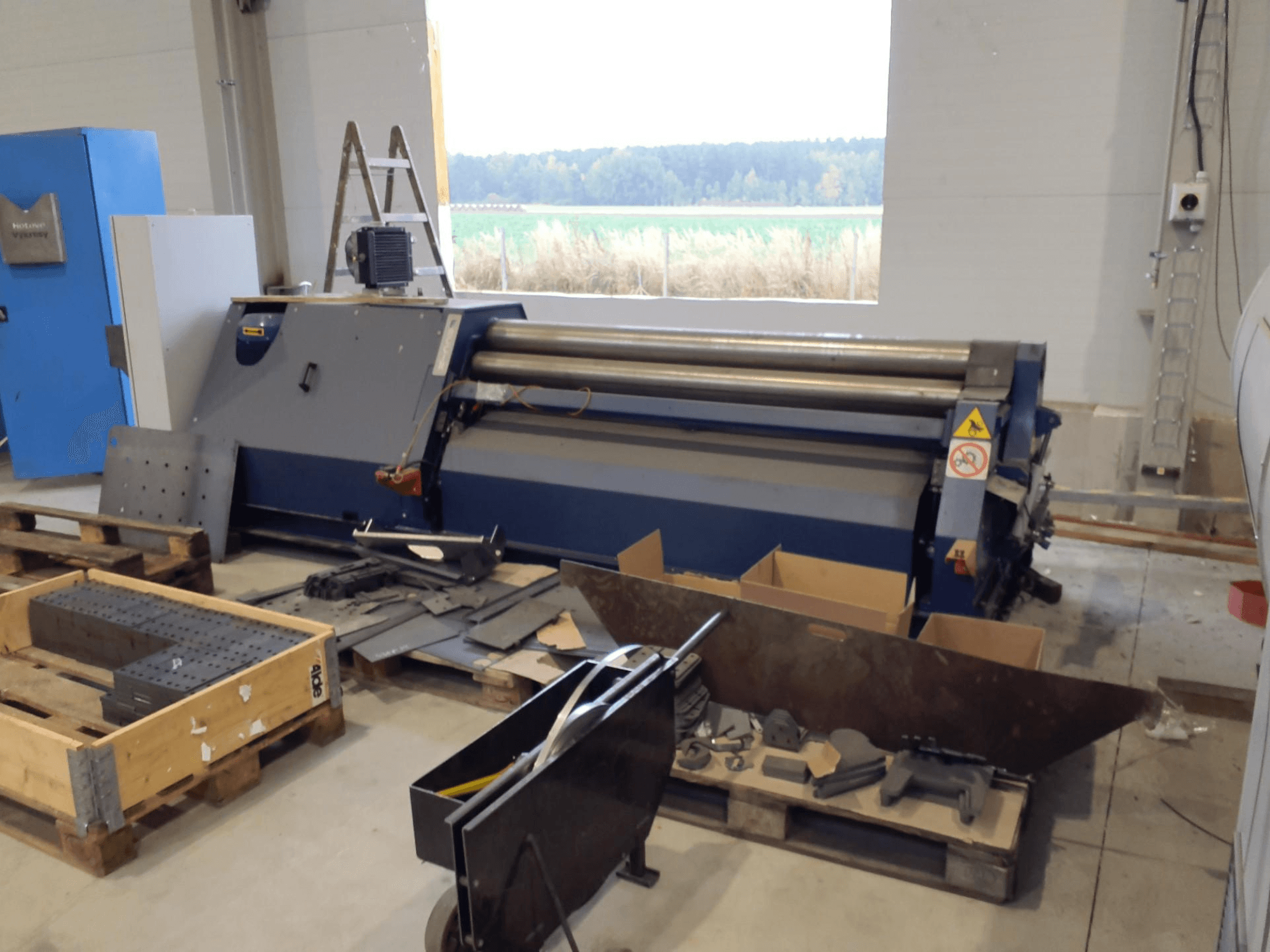 FACCIN 4HEL-2017 Blechwalzmaschine in einer Werkstatt, Vorderansicht mit verstreuten Metallteilen und Werkzeugen.