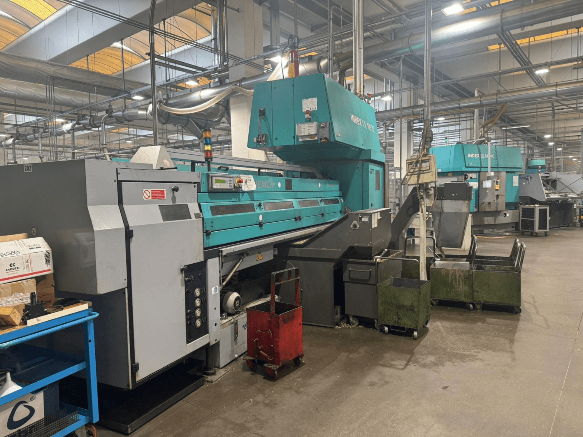 Mehrspindeldrehmaschine INDEX MS32C, Vorderansicht mit Bedienelementen und Arbeitsbereich in einer Werkstatt.