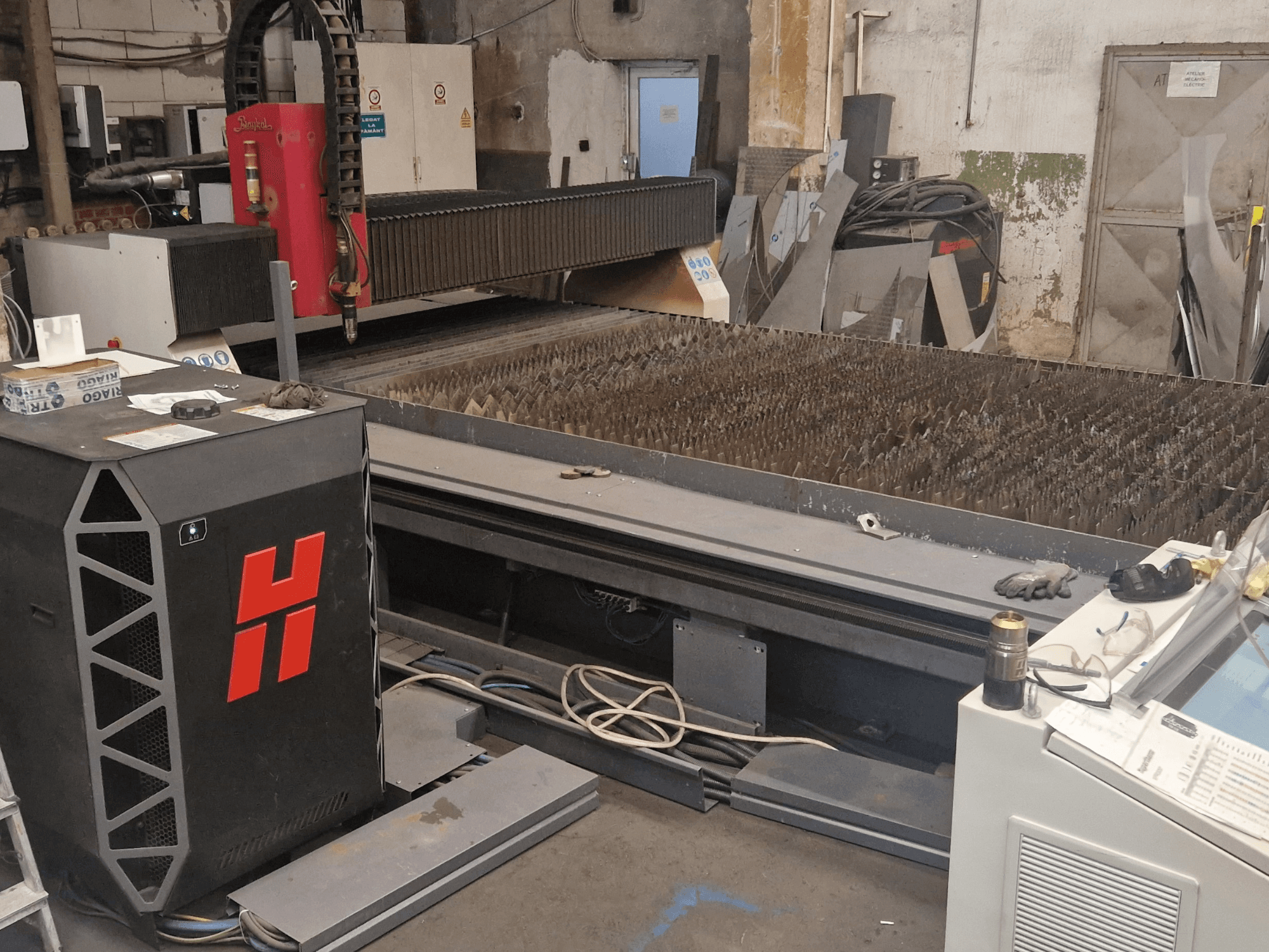 Plasmaschneidemaschine vom Typ Baykal BPS 2004 in einer Werkstatt, Vorderansicht mit Schneidetisch und Bedienfeld.