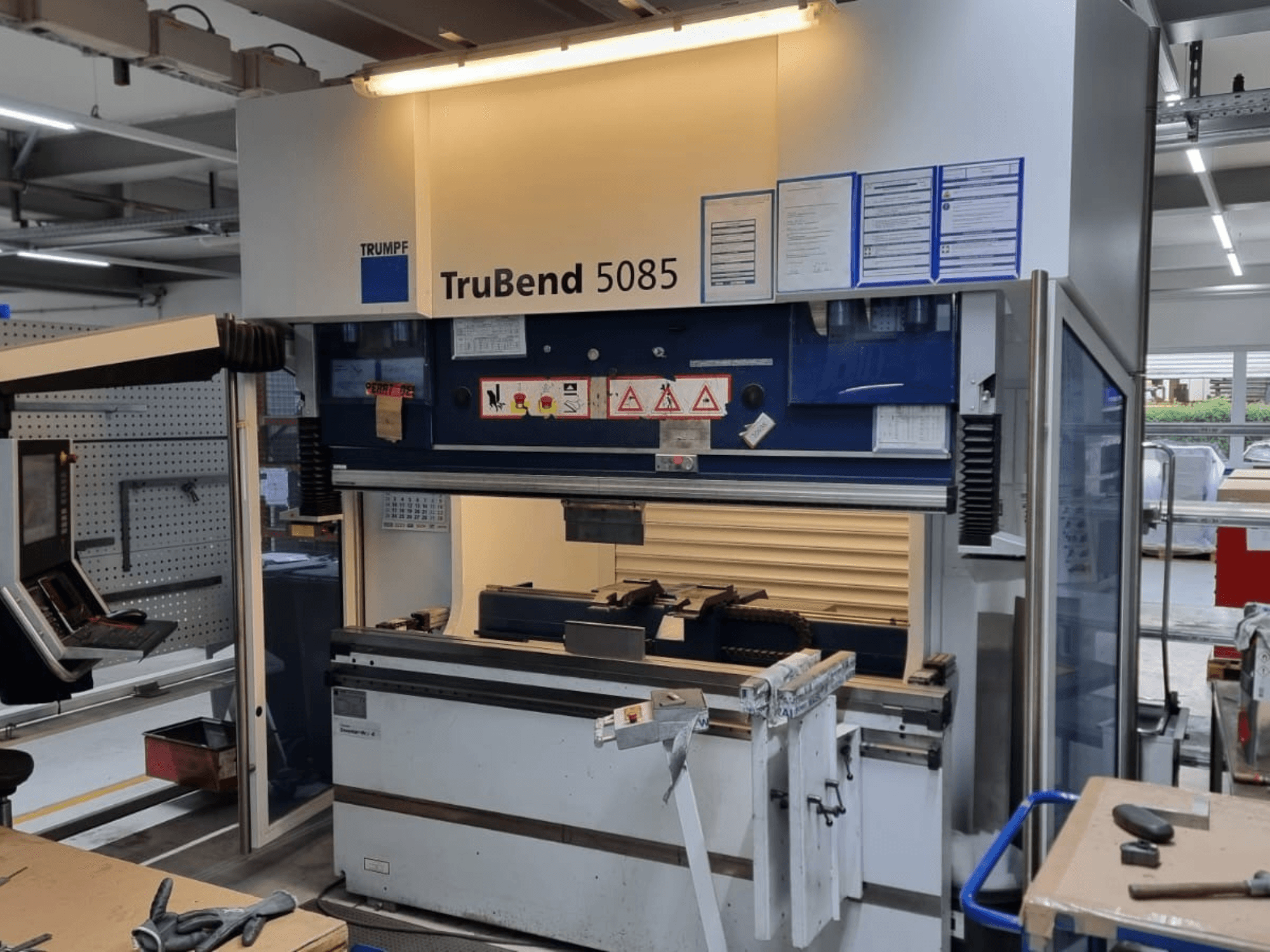 TRUMPF TruBend 5085 Biegemaschine, Vorderansicht, mit Bedienfeld, Bedienplatz und Sicherheitshinweisen in der Werkstatt.