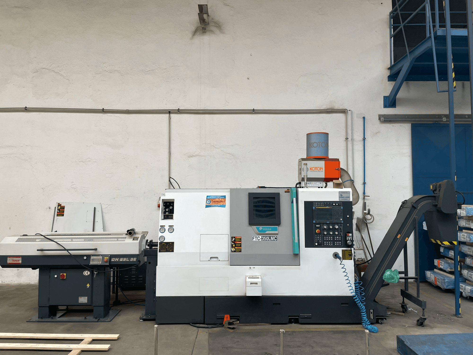 Feeler FTC 350 LMC Horizontal-Drehmaschine in einer Werkstatt, mit Bedienfeld und Werkzeugzuführungsleitungen. Seitenansicht.