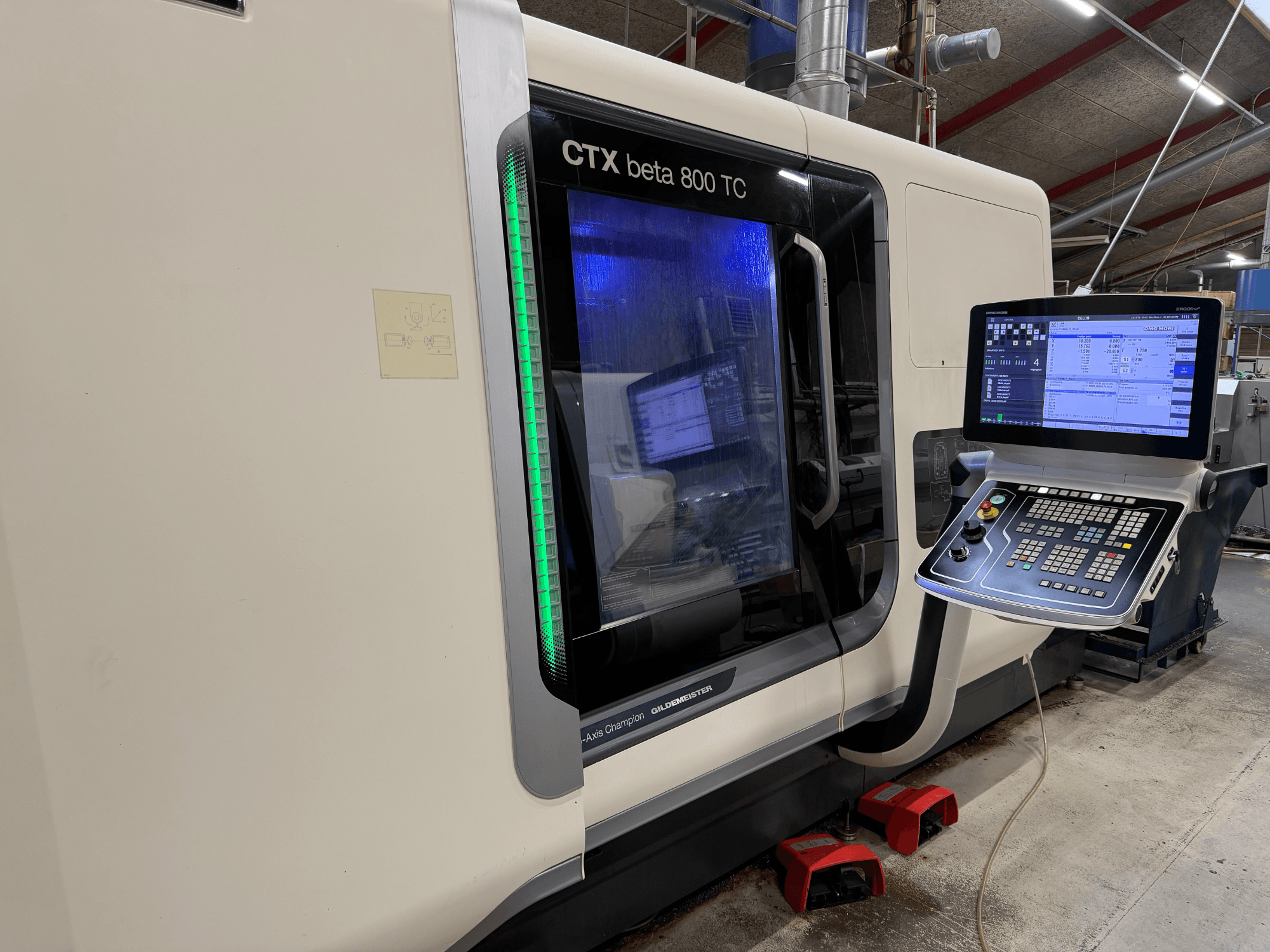CNC-Maschine CTX beta 800 TC in der Seitenansicht, mit digitalem Bedienfeld und grün beleuchteter Sicherheitsanzeige.