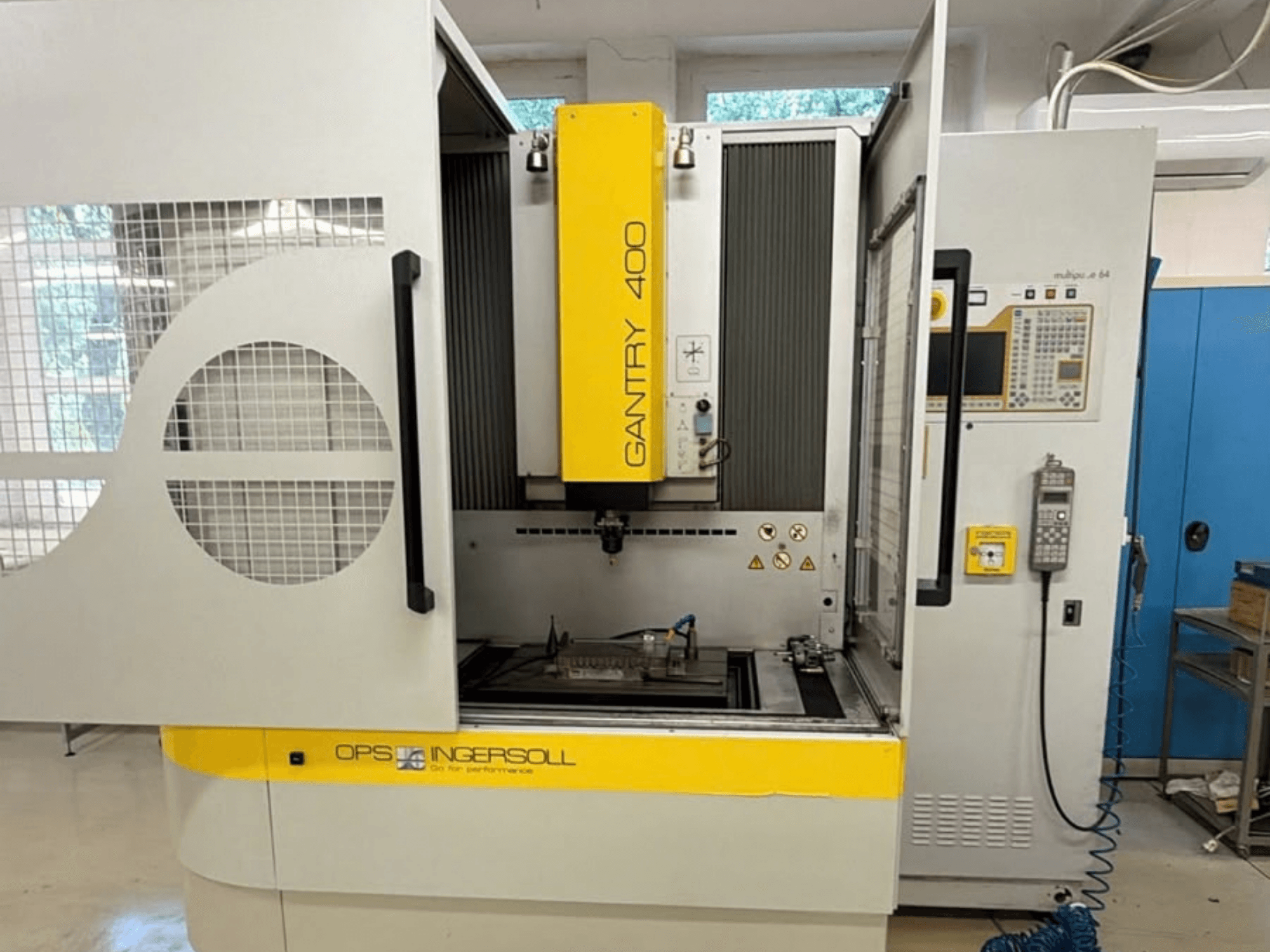 Vorderansicht der Senkerodiermaschine „INGERSOLL Gantry 400“, mit geöffneten Türen und Bedienfeld, wobei sich das Werkstück im Inneren befindet.