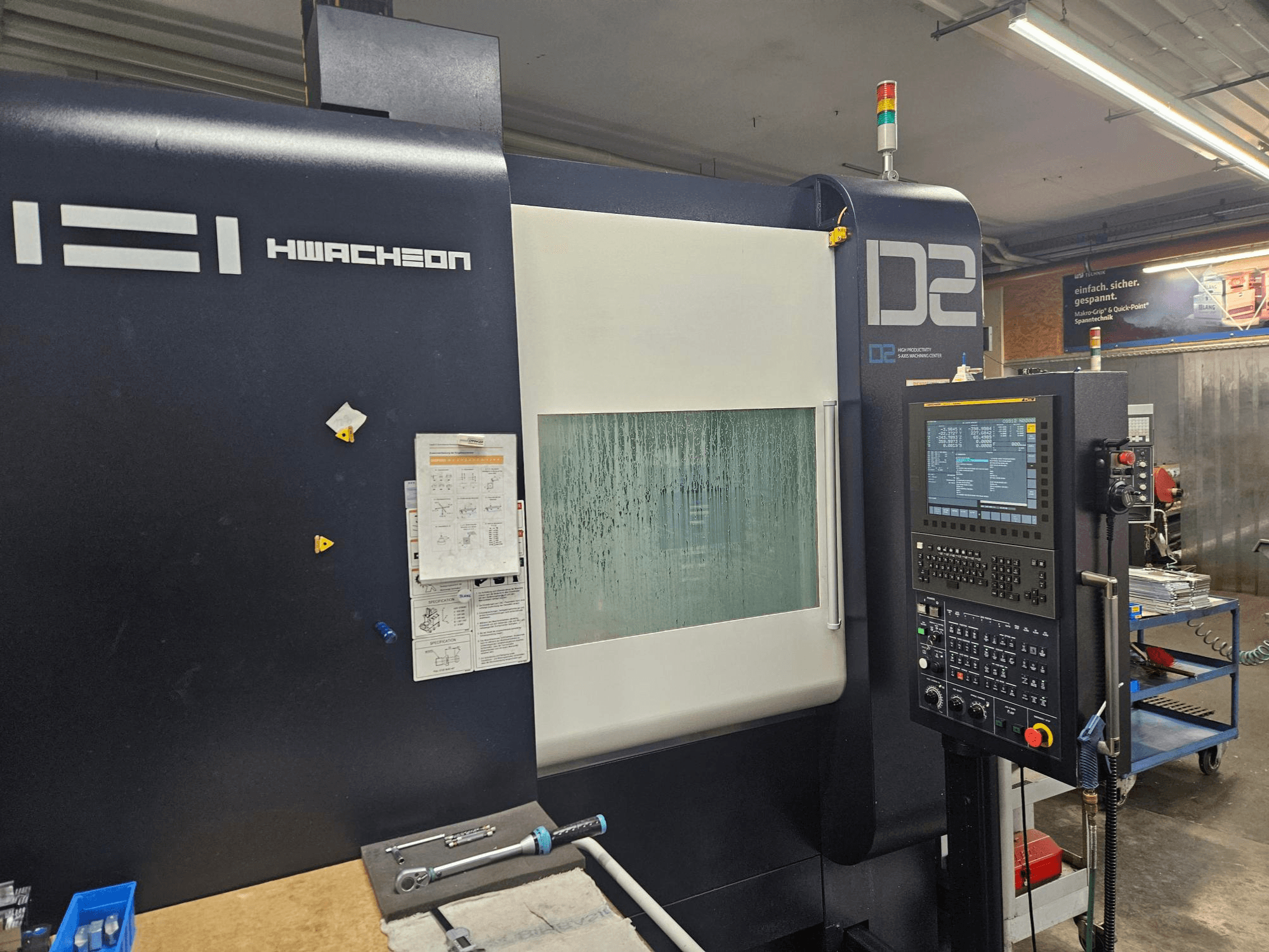HWACHEON D2-5AX 12k Vertikalbearbeitungszentrum, Vorderansicht mit Bedienfeld und beschlagenem Sichtfenster.
