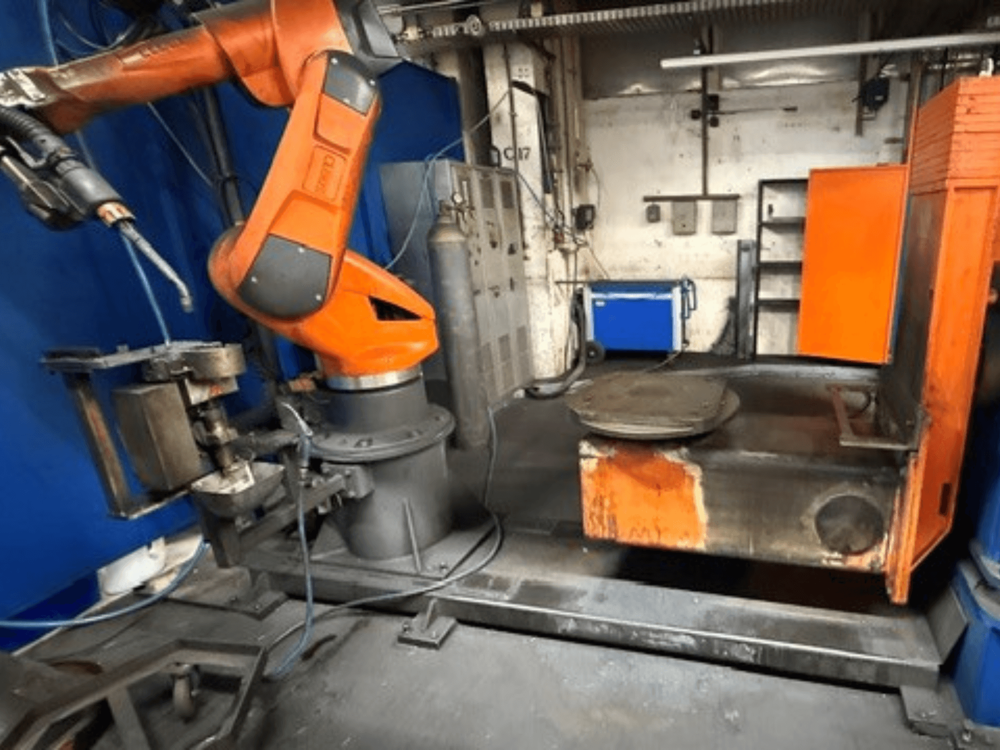 Der Schweißroboter CLOOS C50 in der Vorderansicht, mit einem orangefarbenen Roboterarm und einem Arbeitstisch aus Metall.