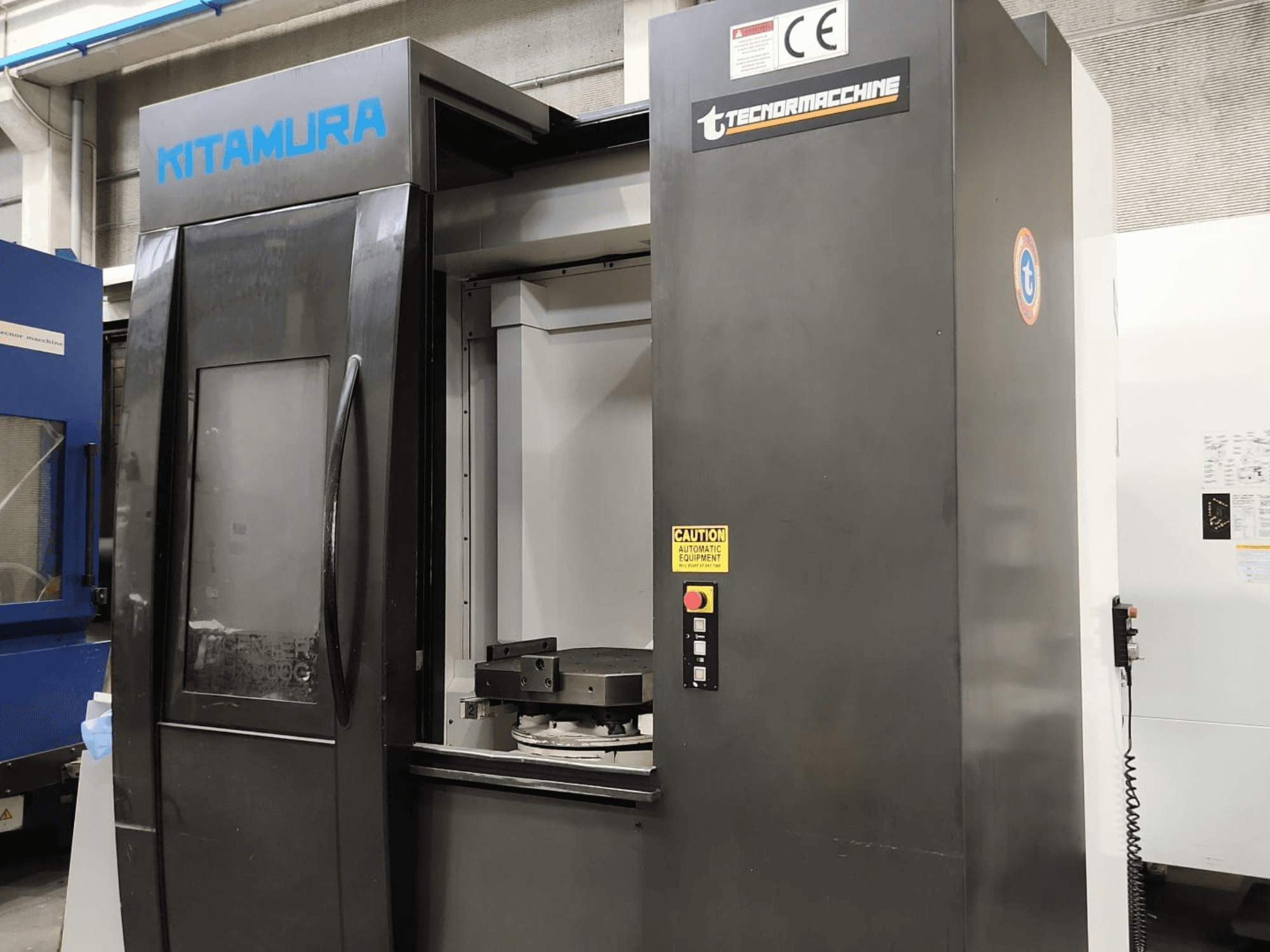 Horizontales Bearbeitungszentrum Kitamura Mycenter HX500iG, Vorderansicht mit Bedienfeld und Arbeitsbereich.