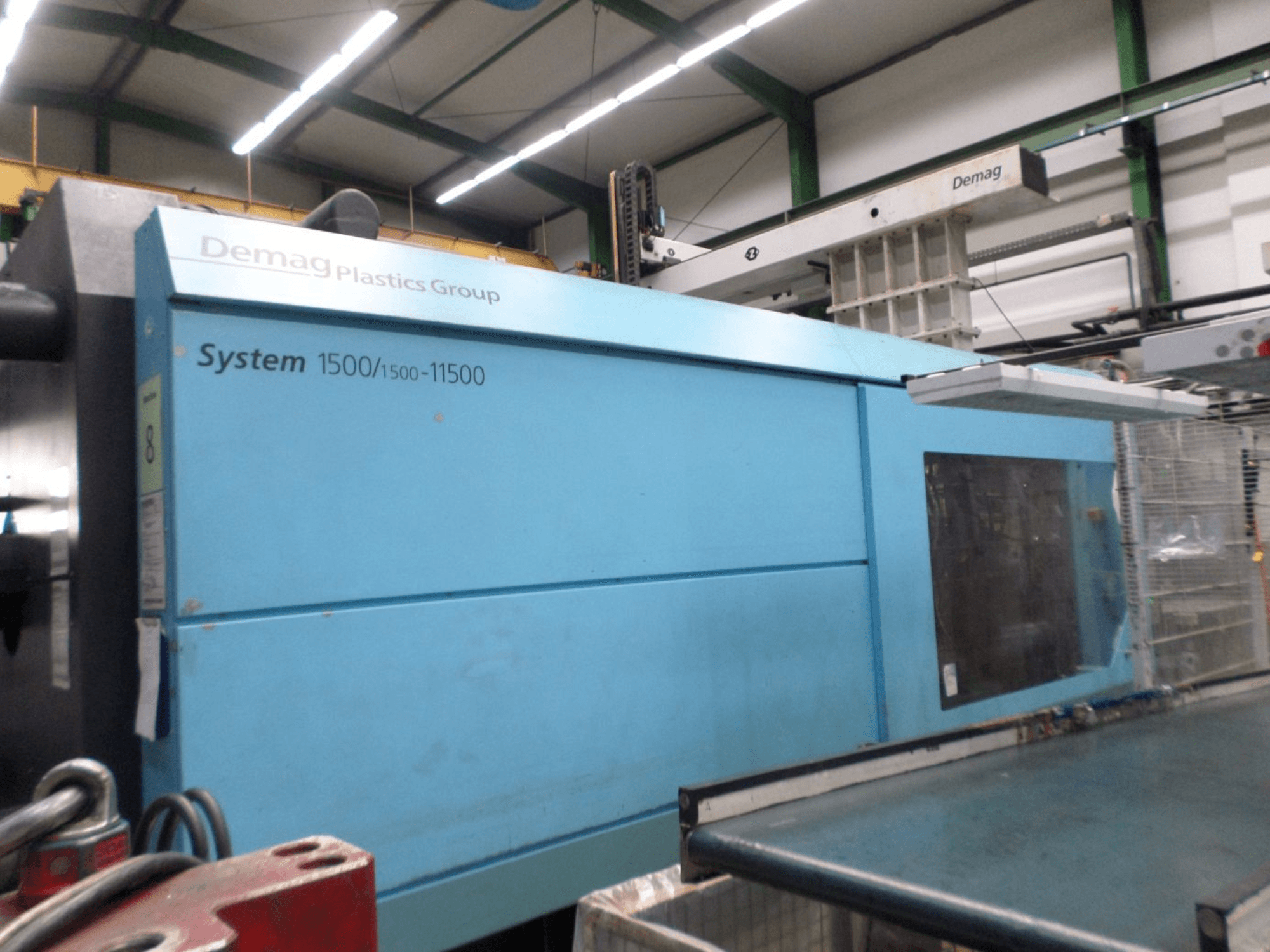 Hydraulische Spritzgießmaschine Demag D 650 in Blau, Seitenansicht mit der Beschriftung „System 1500/1500-11500“ und dem Bedienbereich.