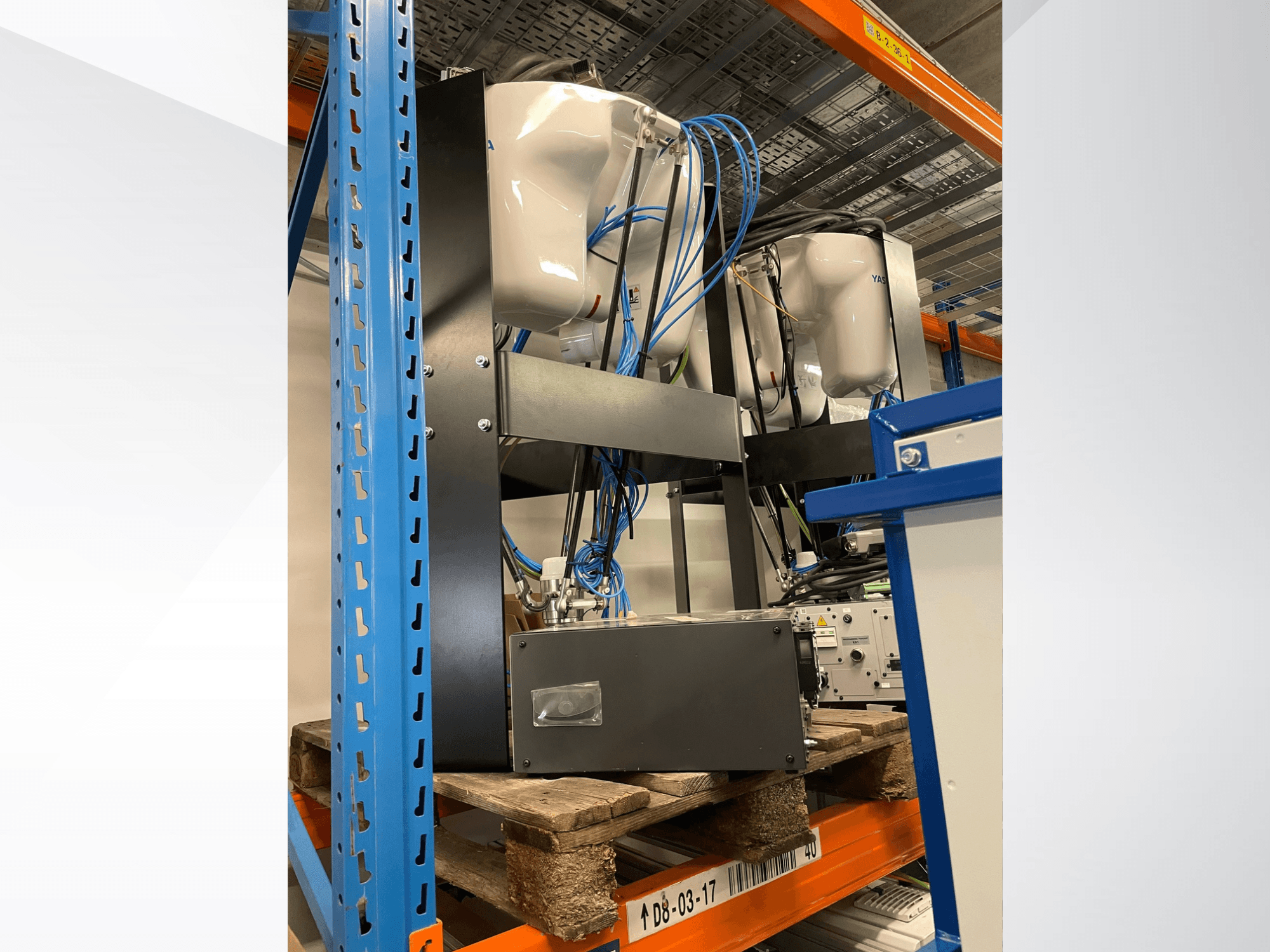 Yaskawa Motoman MPP3H-Roboterarm, dargestellt in Seitenansicht, wobei die Verkabelung und die Komponenten auf einem Regal zu sehen sind.